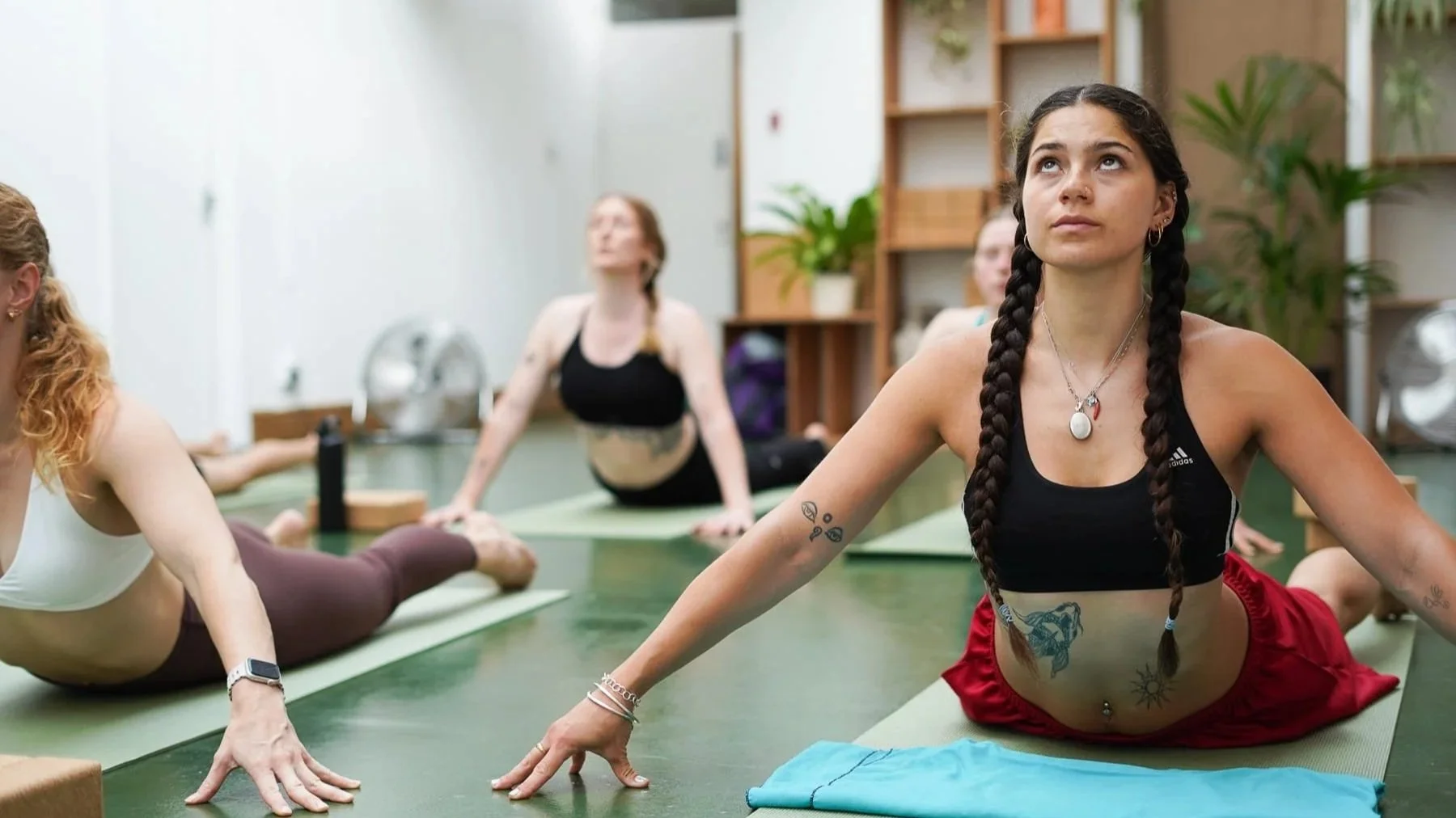 girl in braids doing yoga upward dog on mat with blue towel