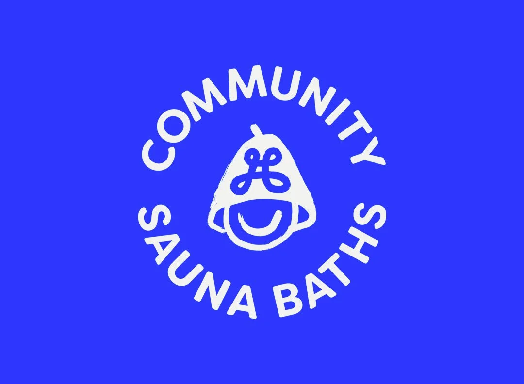 Community Sauna Baths logo: a smiling face in a sauna hat, in white on a bright blue background