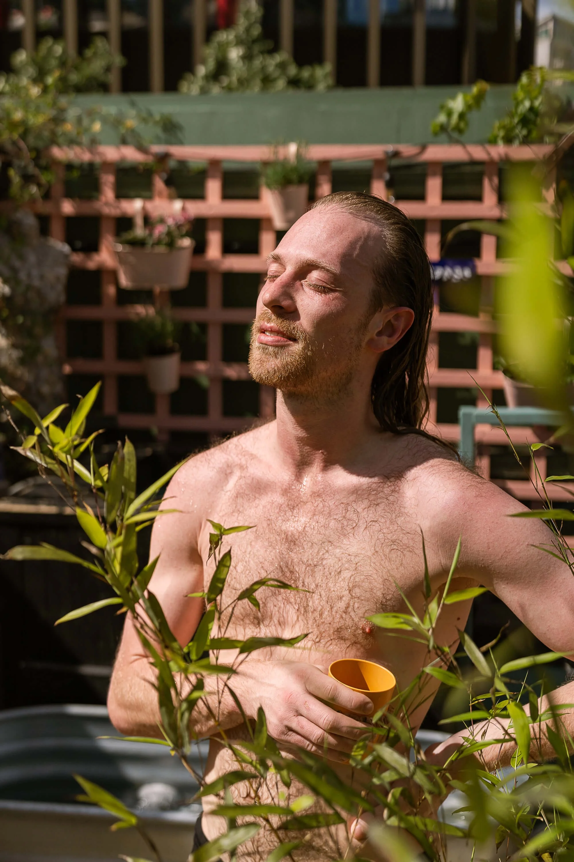 Bather enjoying the sunshine eyes closed community garden stratford sauna baths