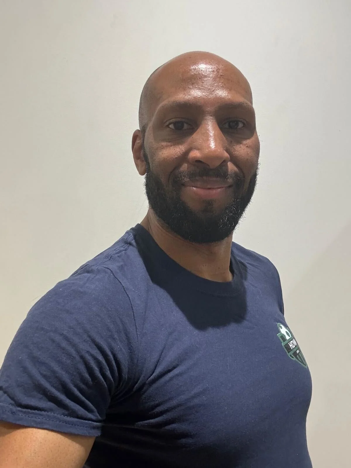 man smiling with a blue tshirt on