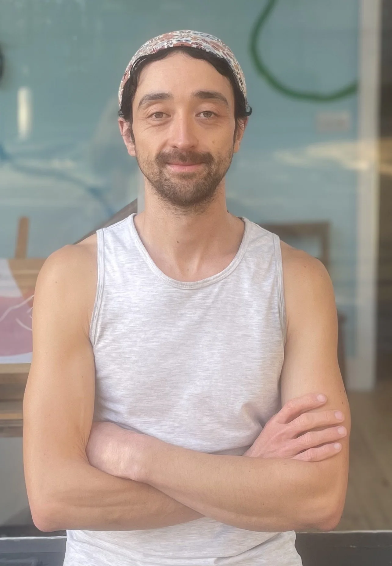 Treatments and therapies practitioner Jonny standing smiling with arms crossed