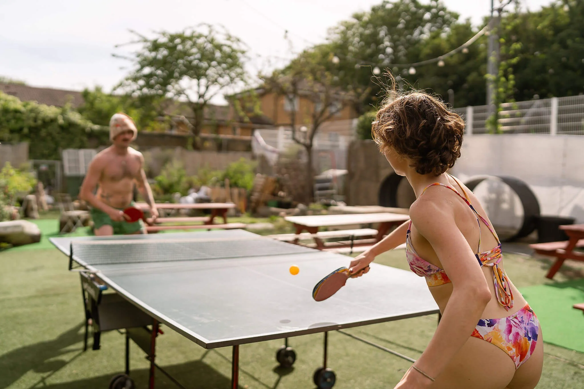People enjoying the garden and ping pong at hackney wick community sauna baths london