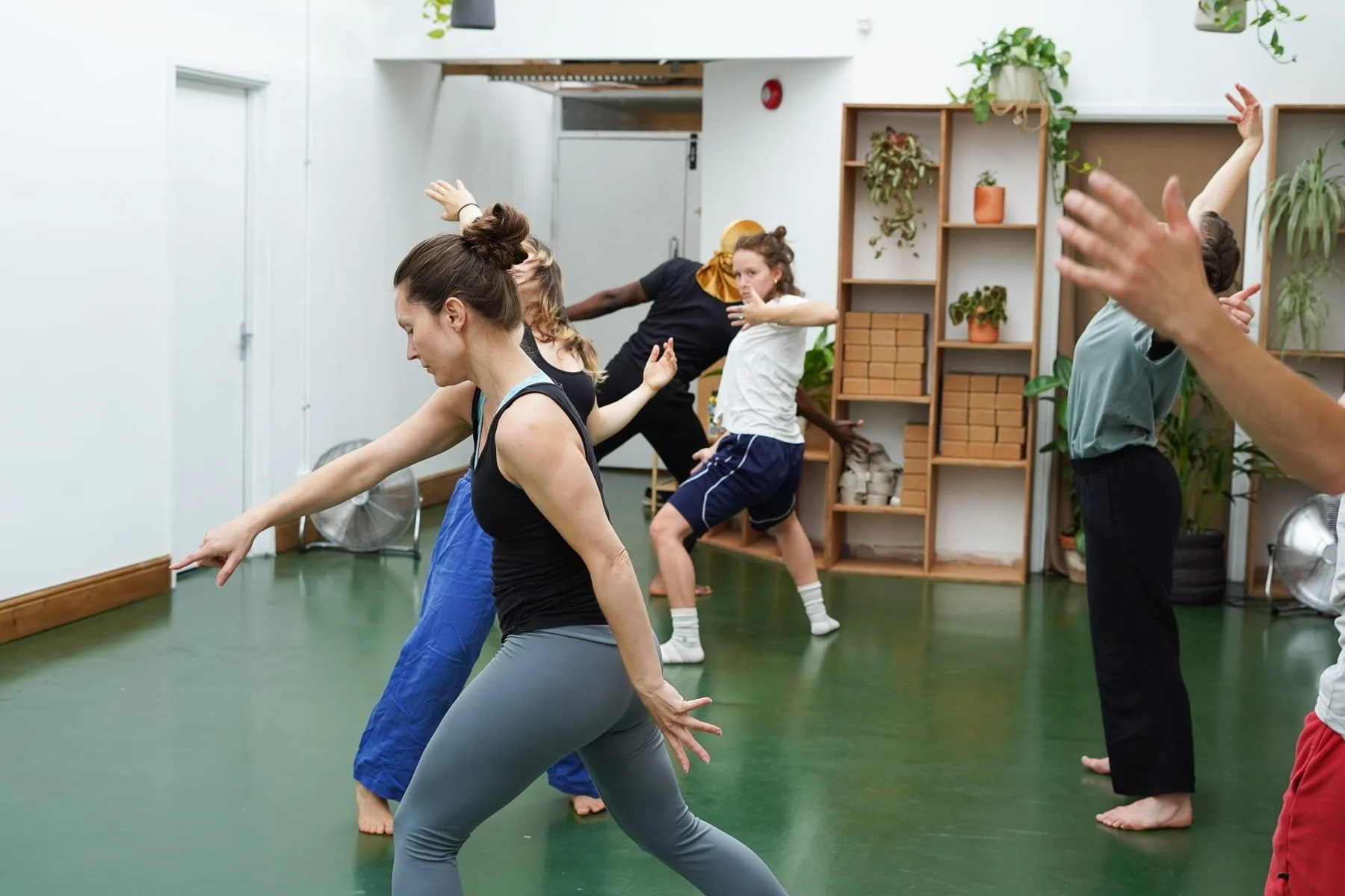 dancers moving around the room with arms moving