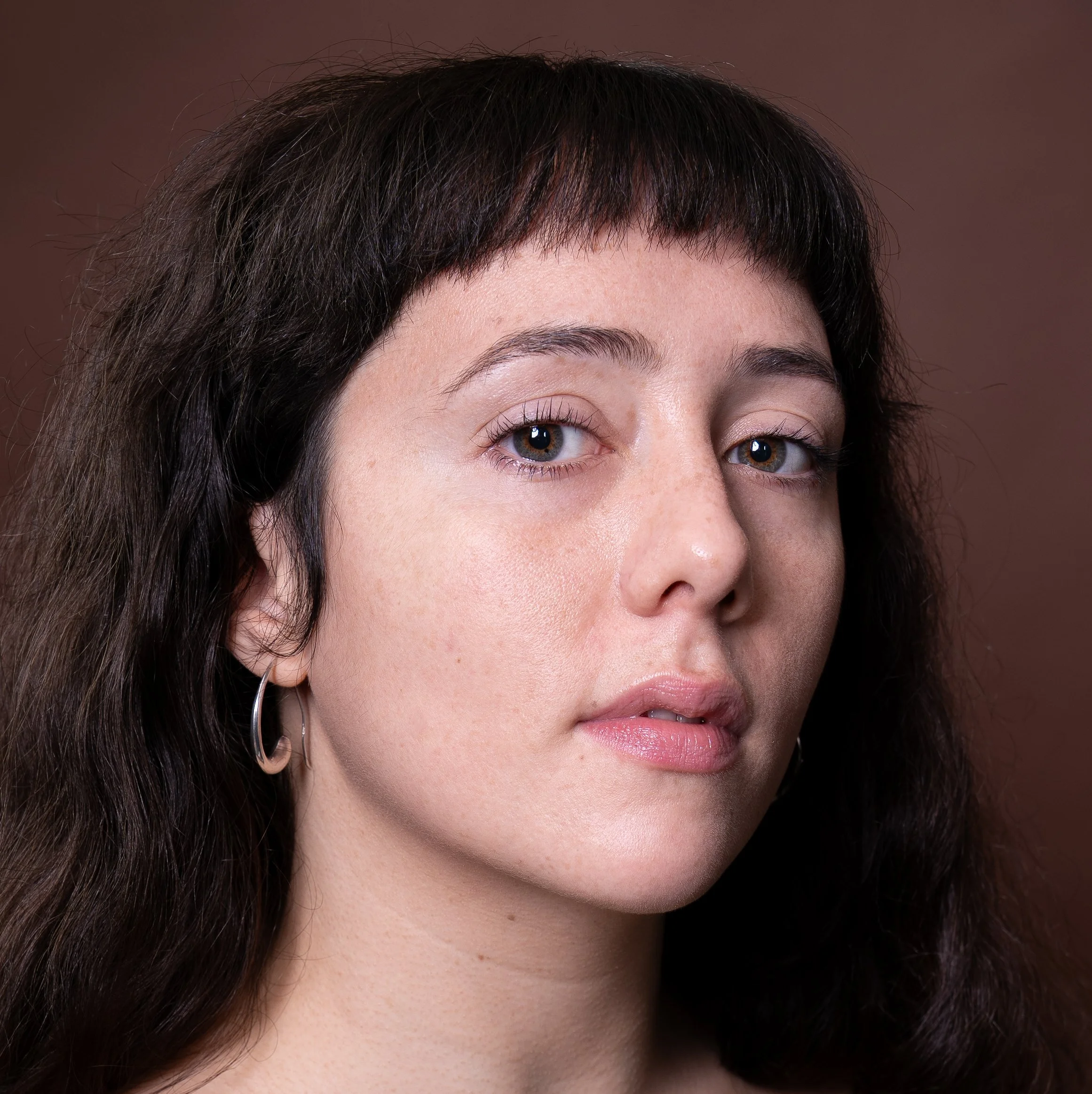 headshot of reiki practitioner dark hair and fringe looking into the camera