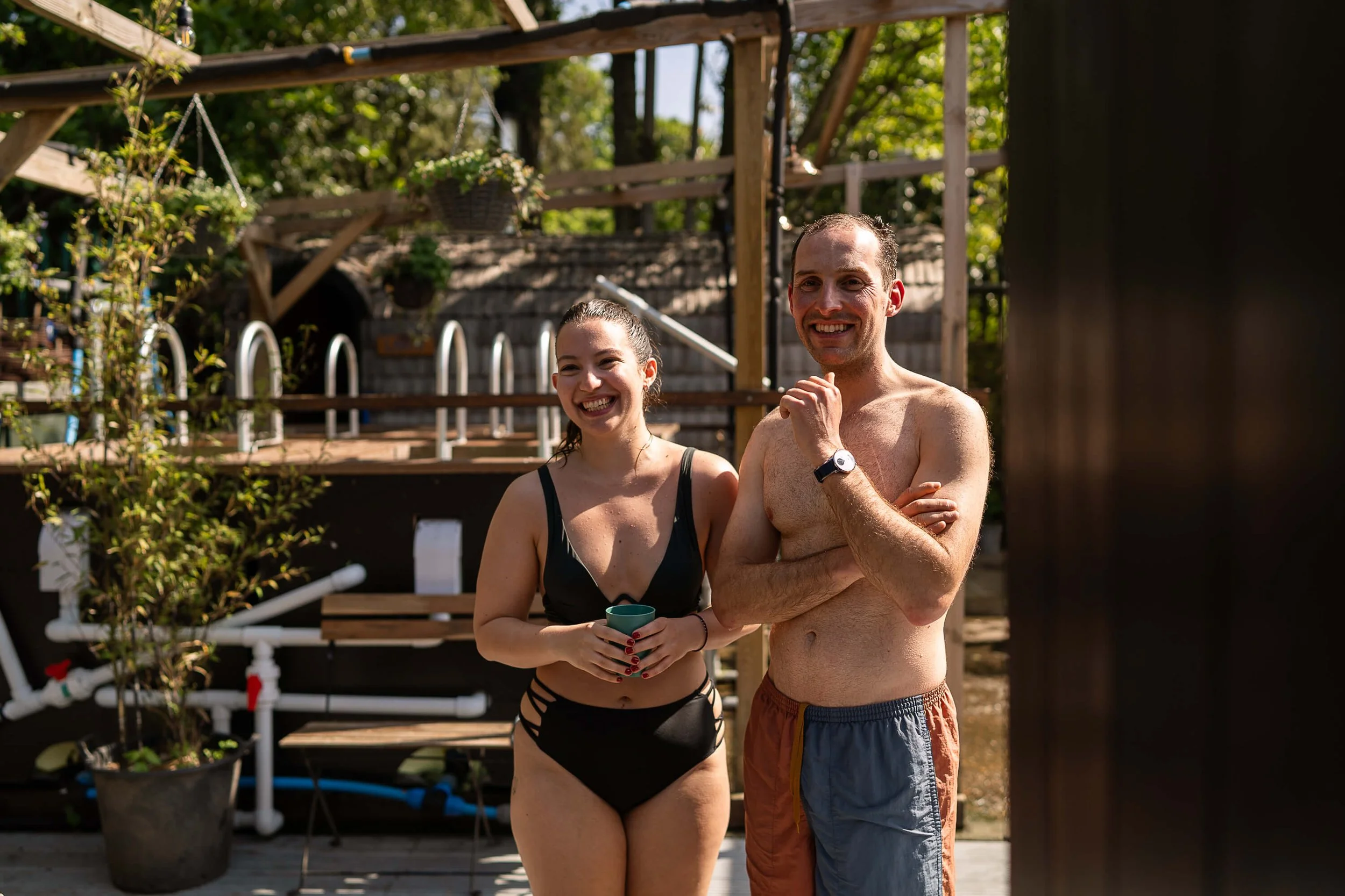 two bathers smiling in swimsuits one holding cup camberwell community sauna baths