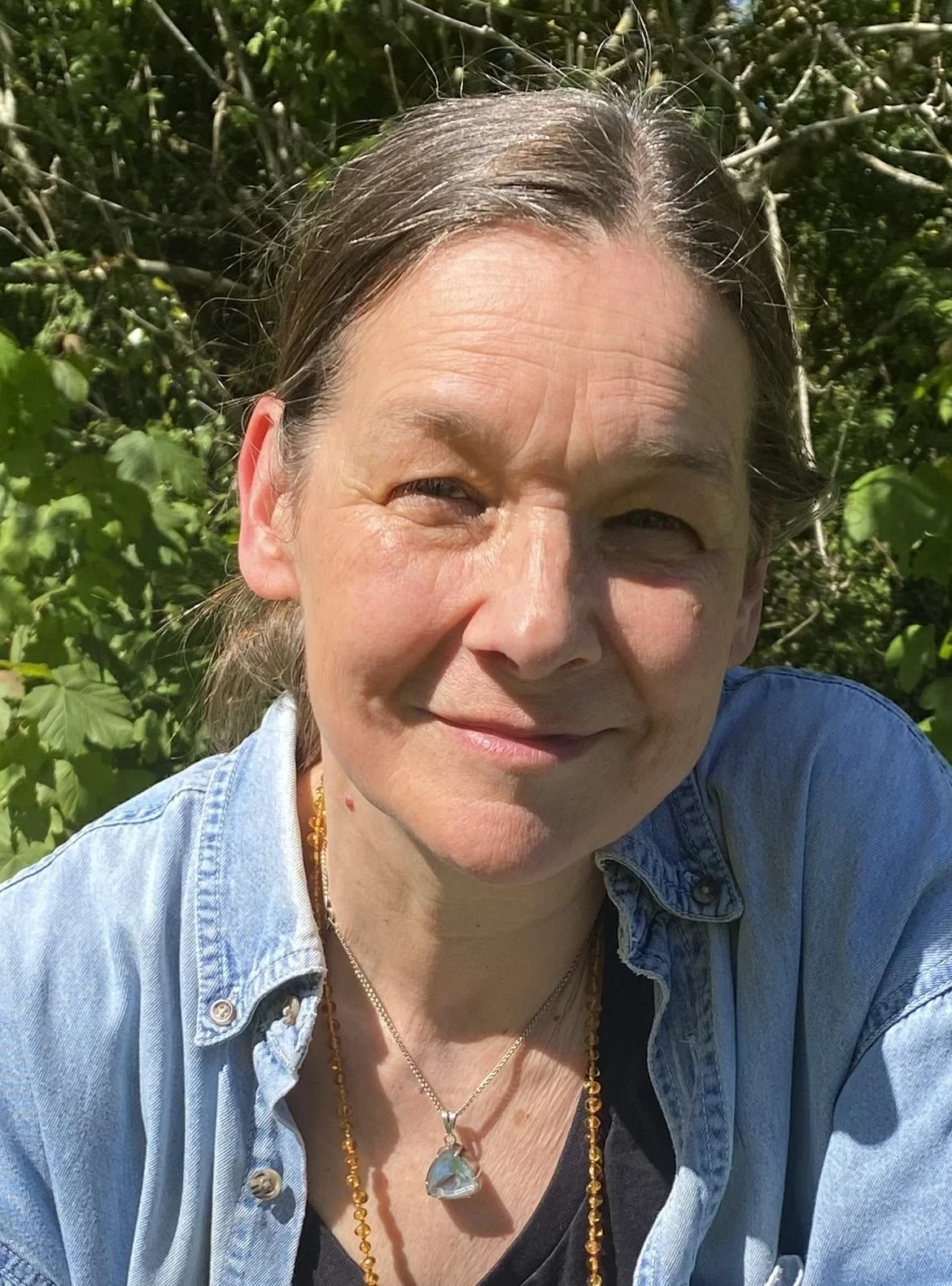 practitioner trudy smiling in the sunshine in a denim top