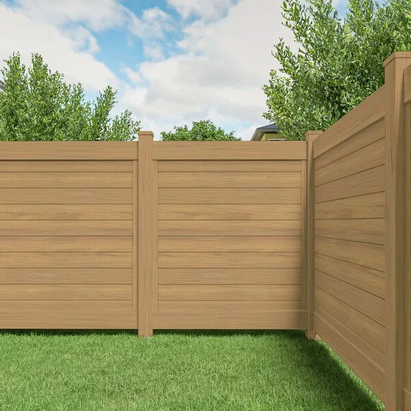A wooden privacy fence in a backyard with green grass and trees, under a partly cloudy sky.