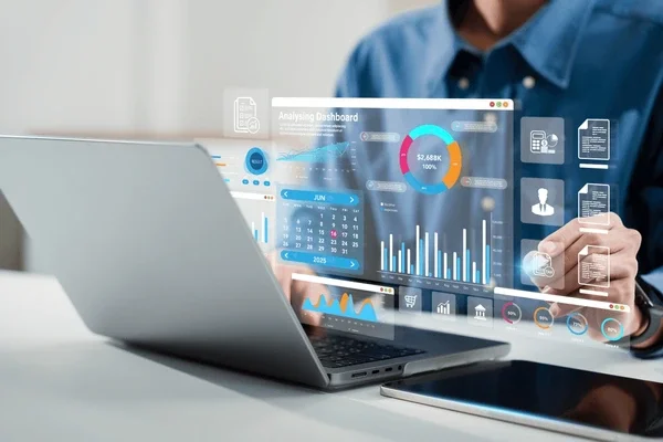 A person sitting in front of their laptop with holographic icons showing analytical growth on a dashboard.