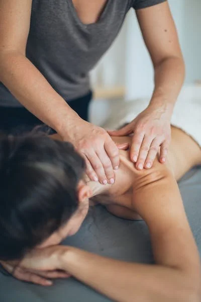 A person giving a massage to another person's shoulder and neck.
