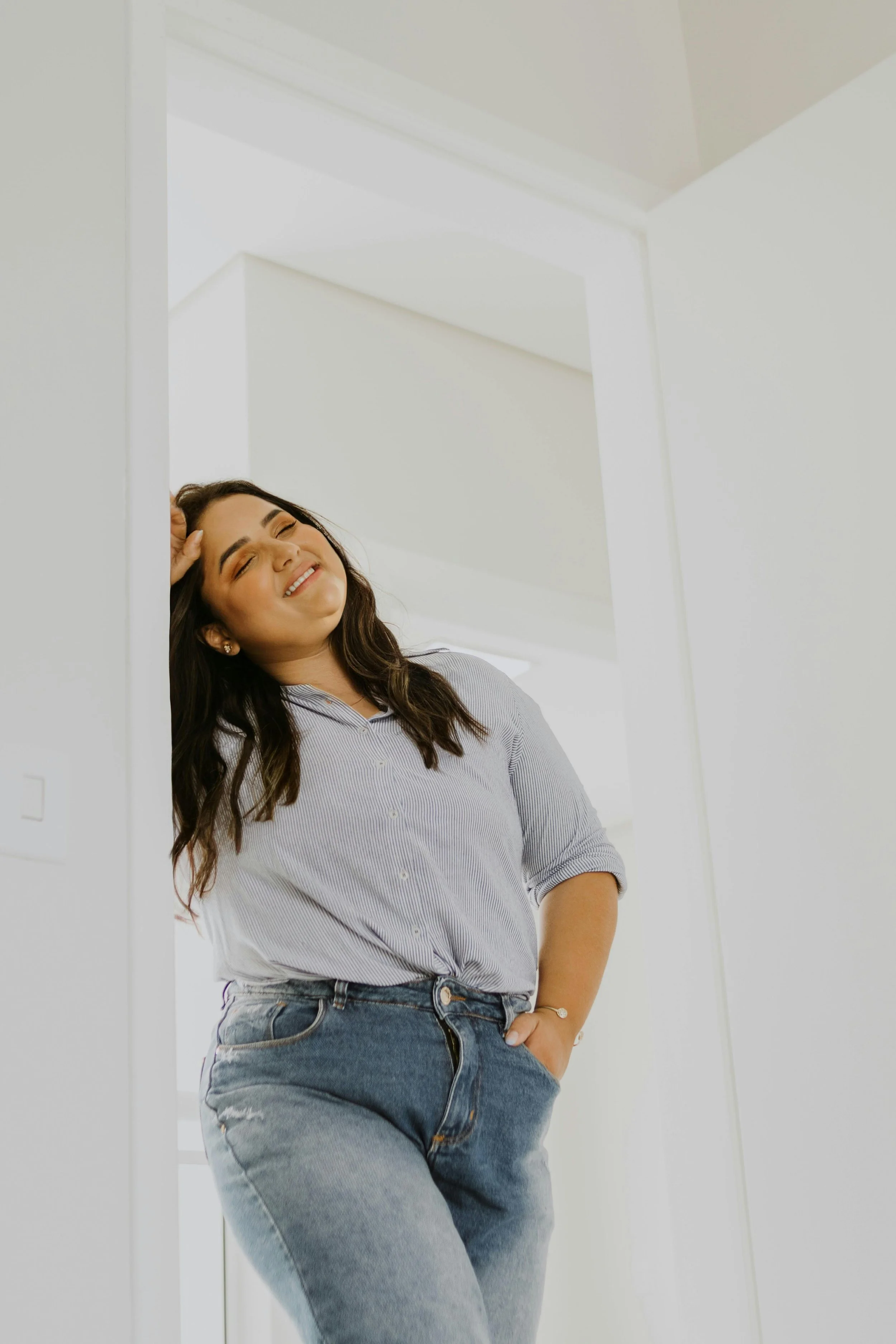 a smiling woman leaning against a doorframe