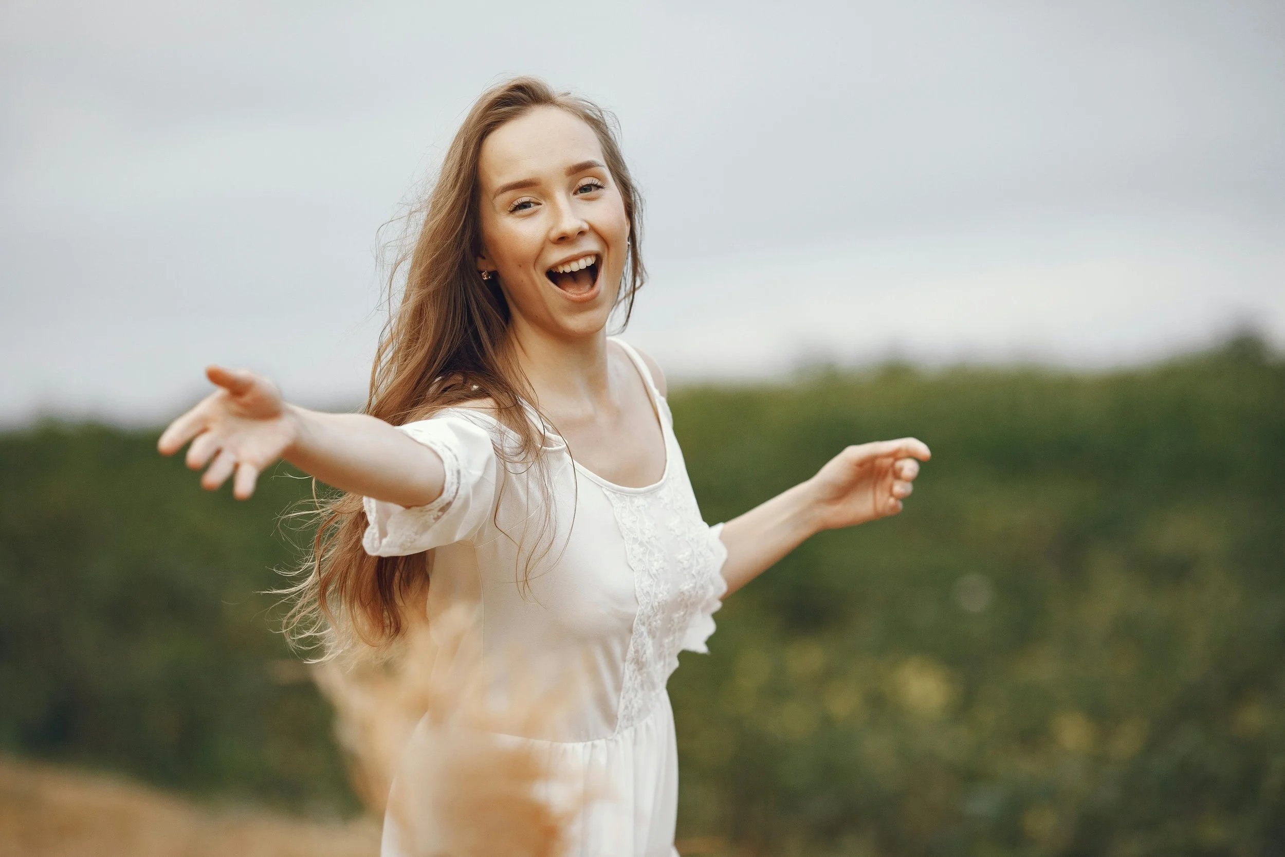a woman outside playfully tossing flowers