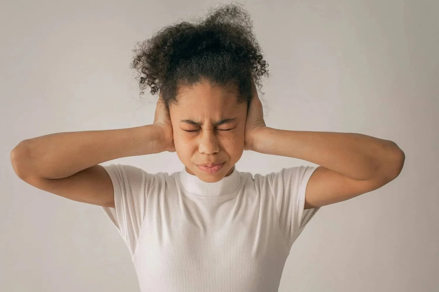 woman covering her ears