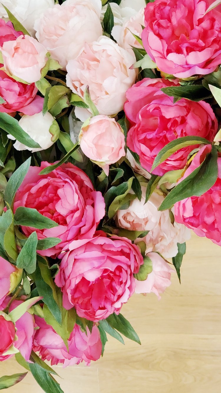 An image of a bouquet of light pink and dark pink peonies.