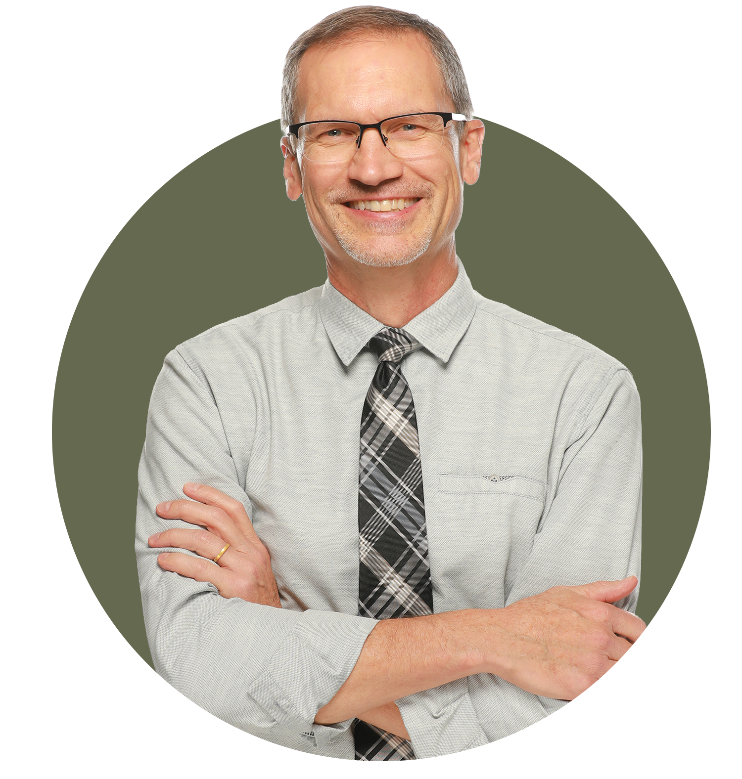 Portrait of Paul Dybdahl: A middle-aged man with glasses and short hair, smiling with arms crossed, wearing a gray shirt and a plaid tie.