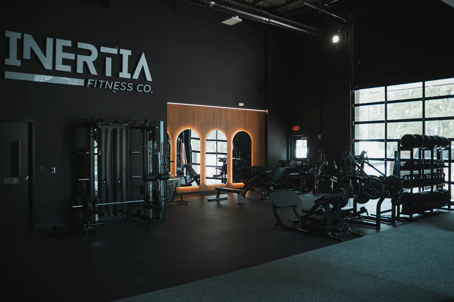 The spacious Inertia North Charlotte studio with strength equipment and backlit mirrors
