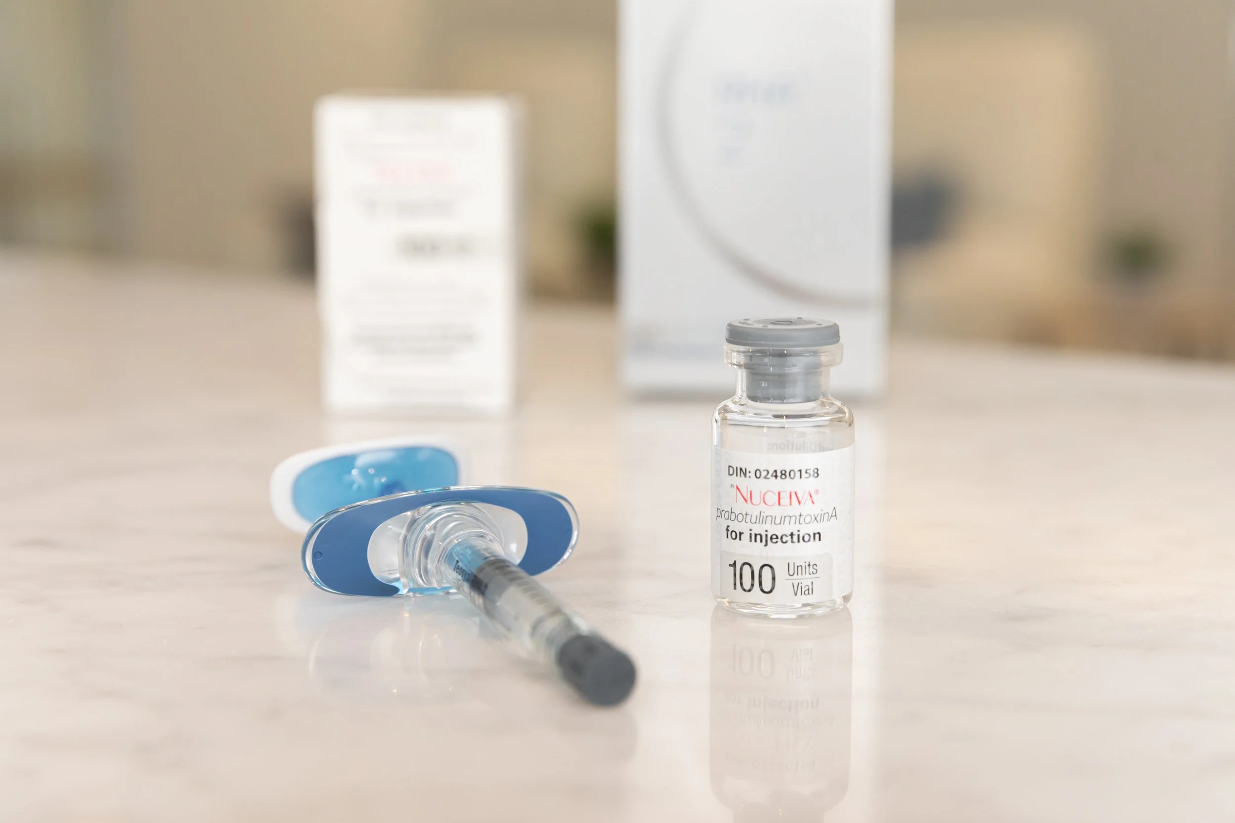  a bottle of botox (nucieva) on a counter with a syringe of filler 