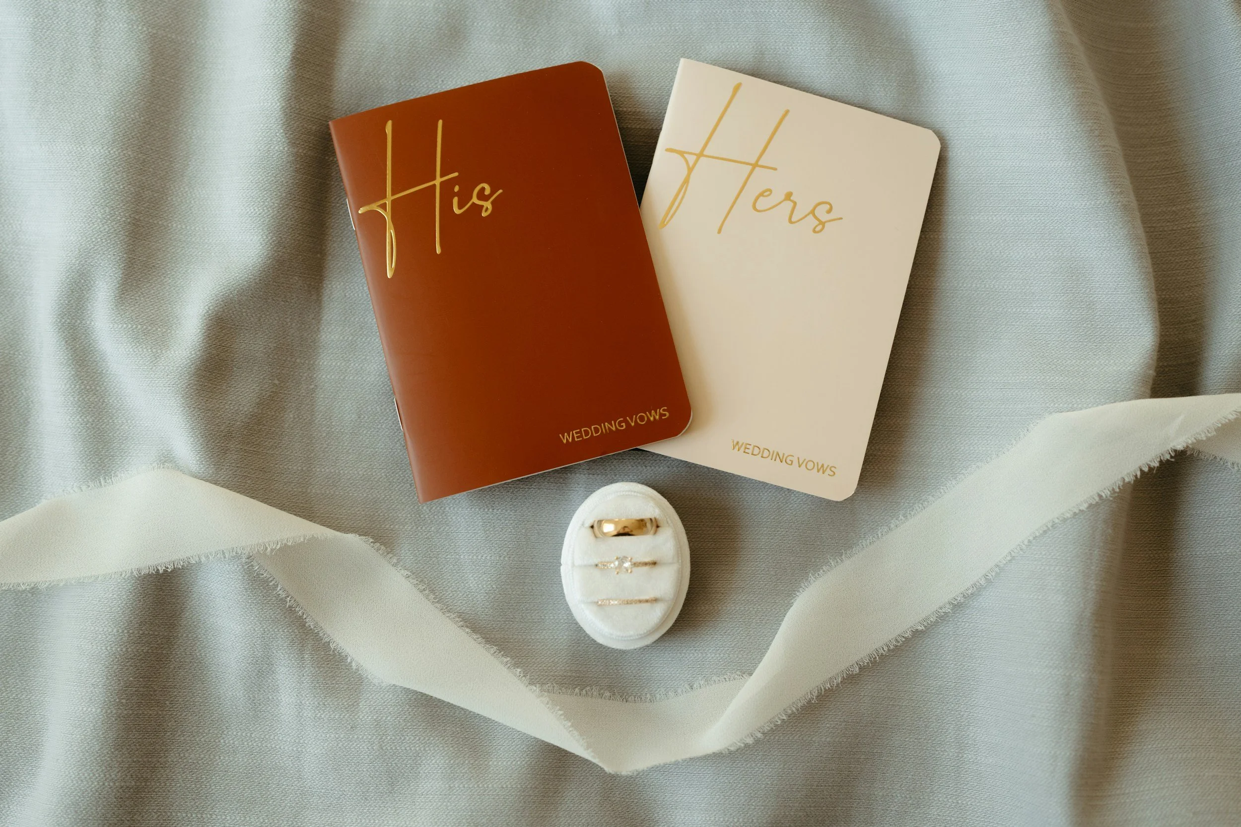 Wedding vow booklets, engagement ring, and pen styled for inspiration for writing meaningful wedding vows