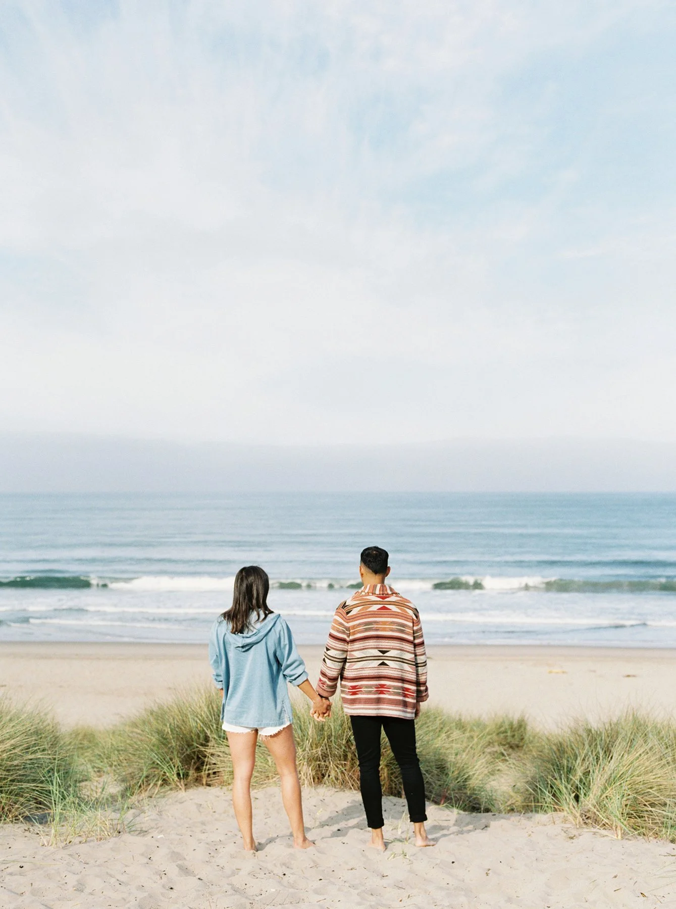 Engaged couple by the ocean celebrating their upcoming wedding day
