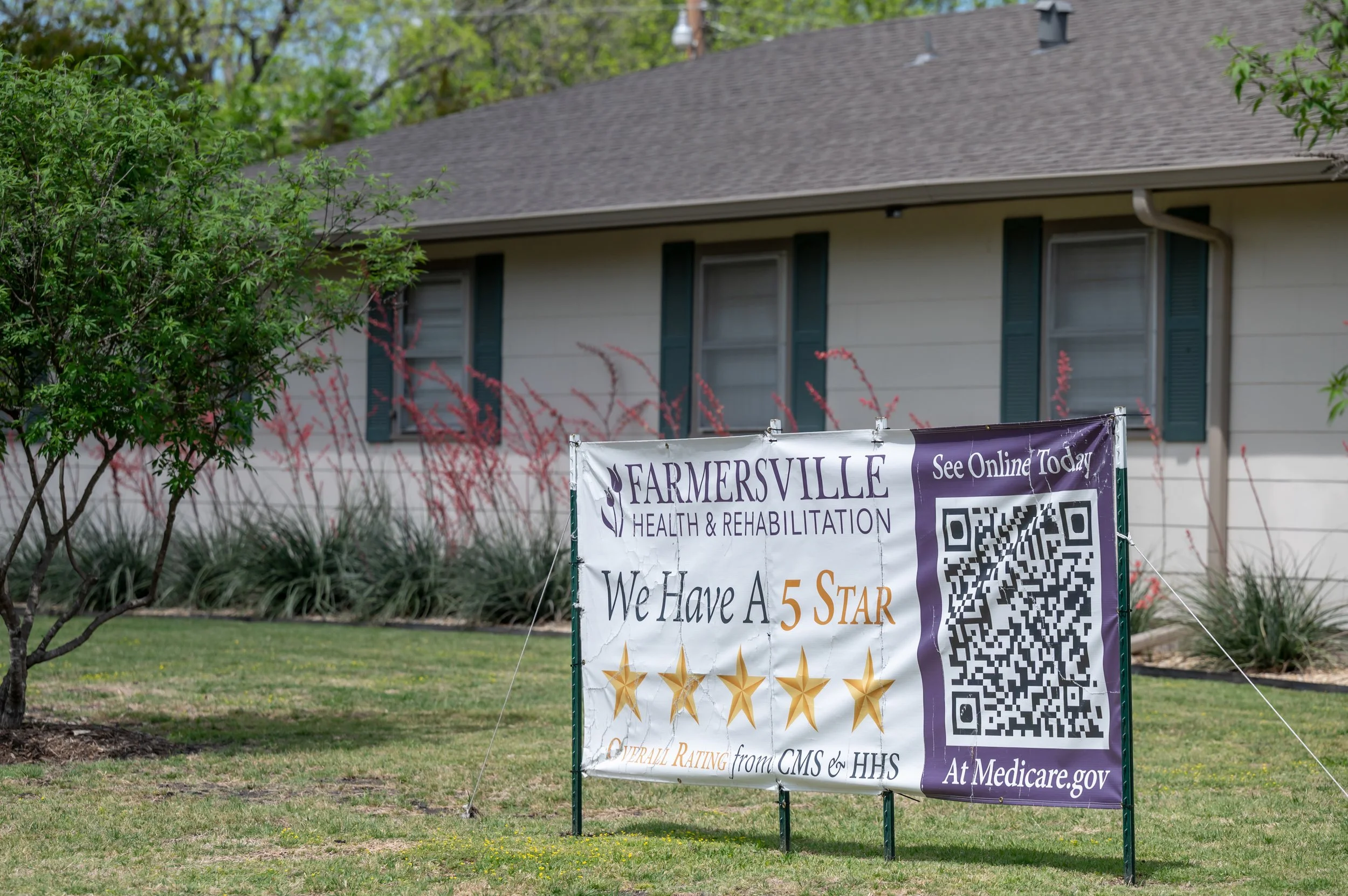 A lawn sign outside a house promotes Farmersville Health & Rehabilitation, claiming a 5-star rating from CMS and HHS, with a QR code and website link for online information.