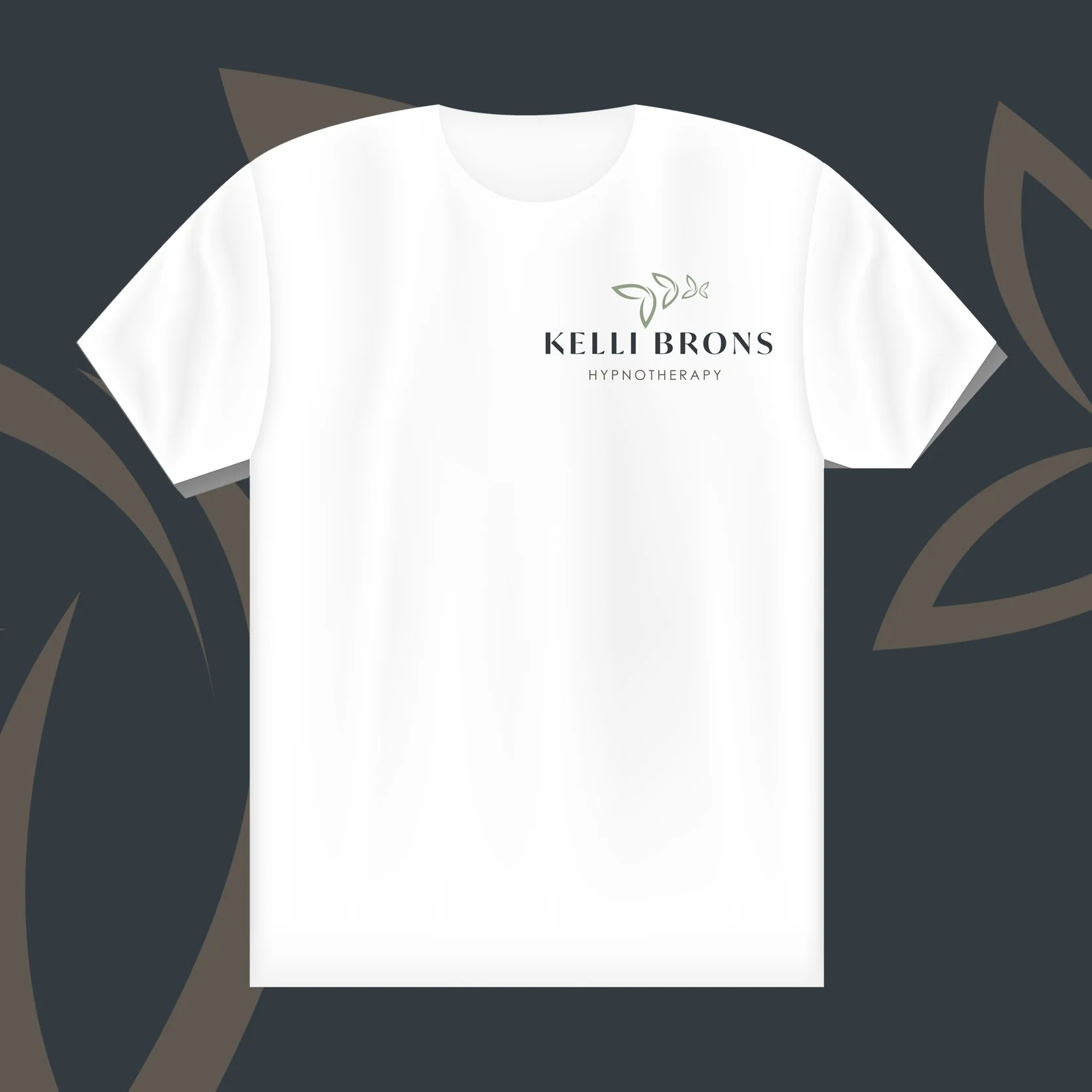 White t-shirt with logo and text reading 'Kelli Brons Hypnotherapy' on a dark background with leaf motifs.