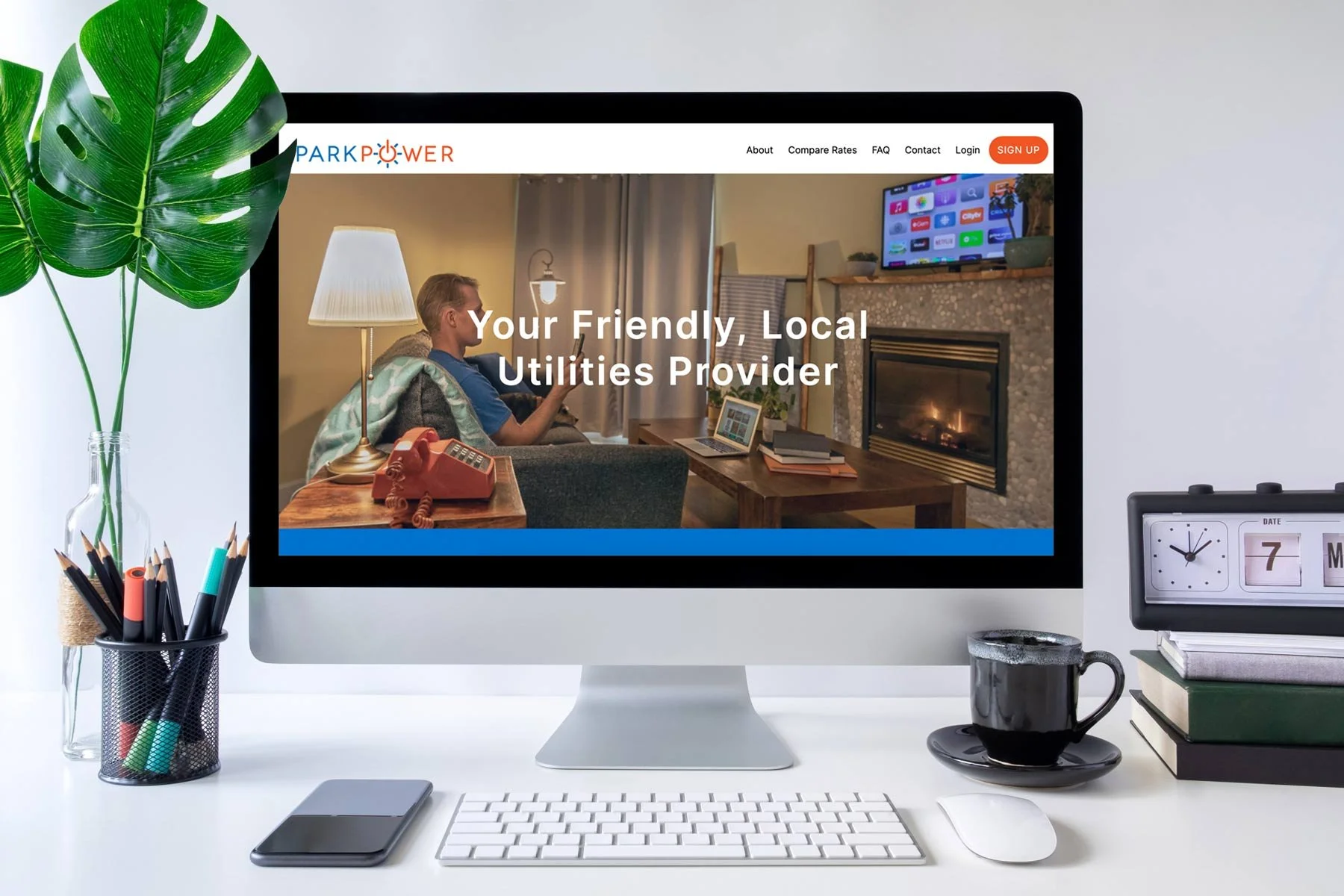 Desktop showing a utilities provider website with a man using a remote in a cozy living room setting with a fireplace and wall-mounted TV.