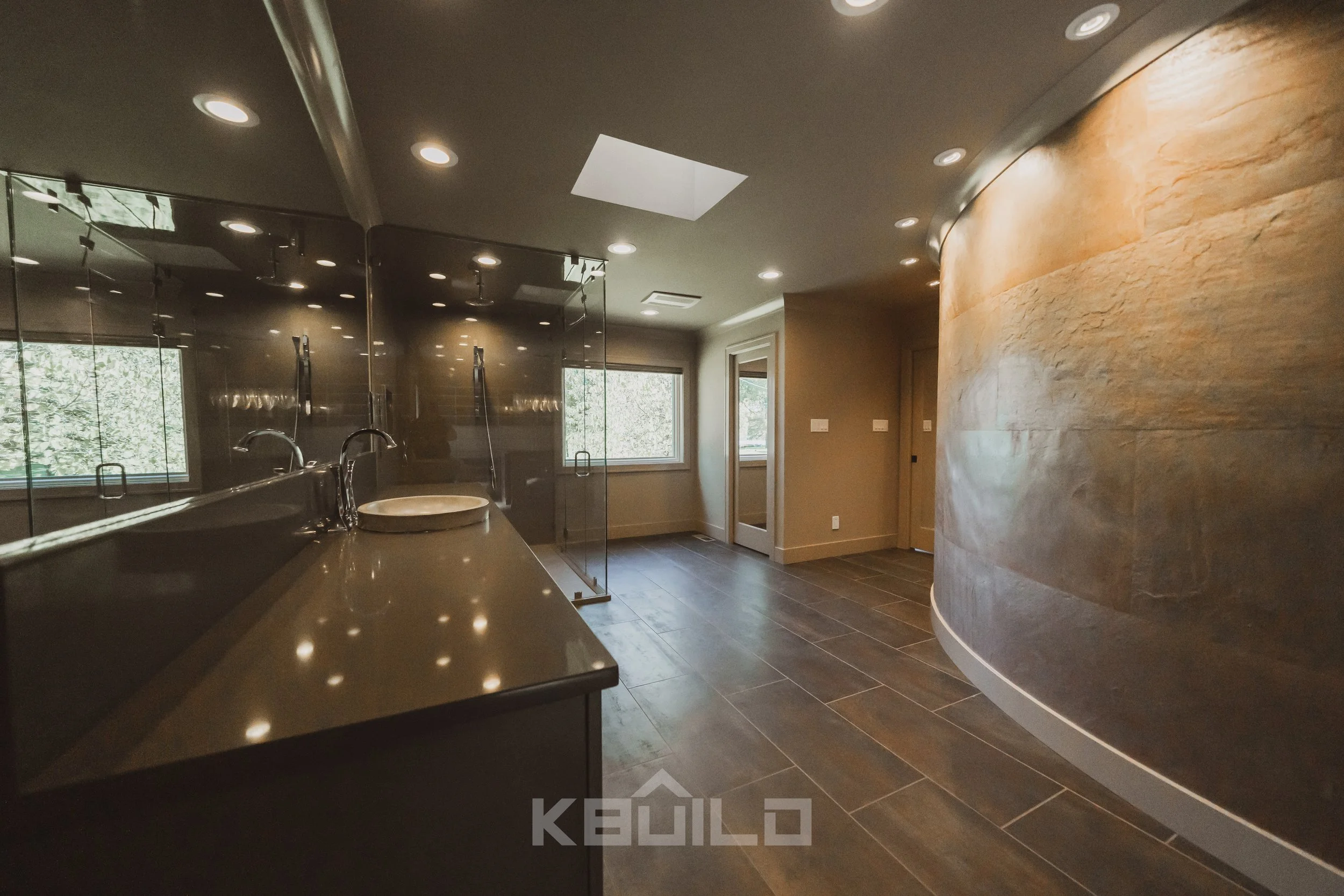 Master bathroom with dark gray tile flooring, a large vanity with bowl sink, and a massive shower stall