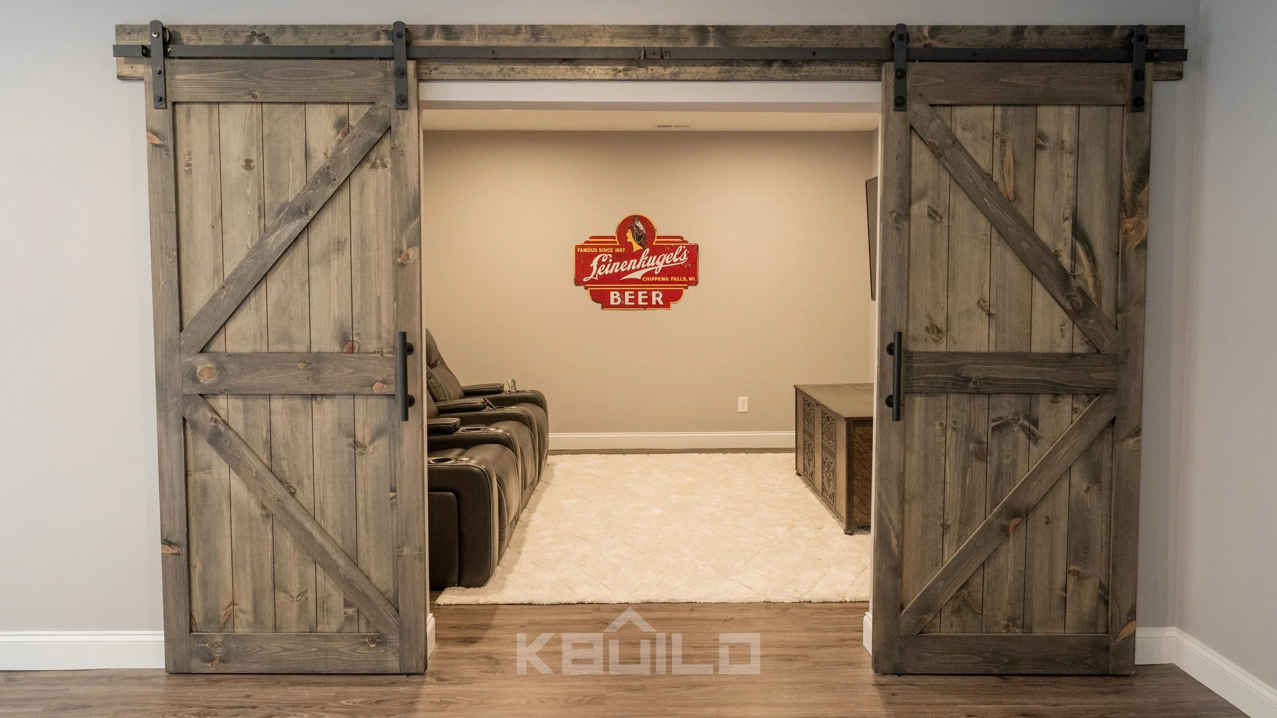 Open sliding barn doors leading into a home theatre in basement