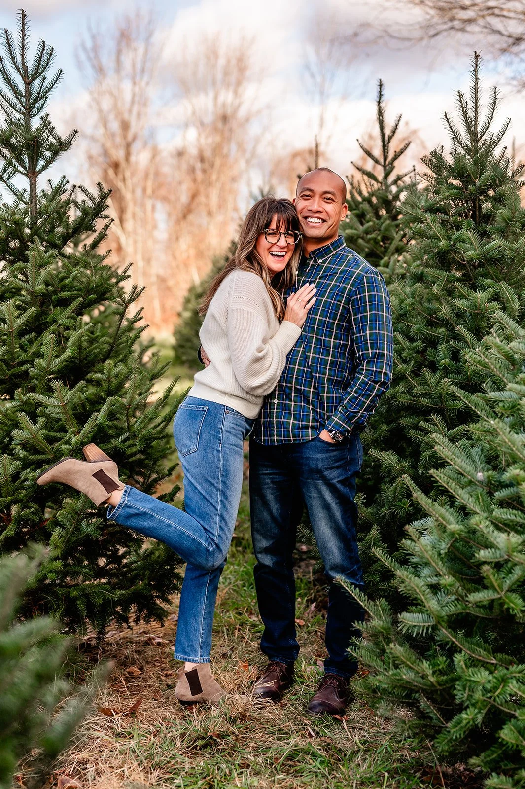 A couple poses together on a Christmas tree farm in New Hartford Connecticut