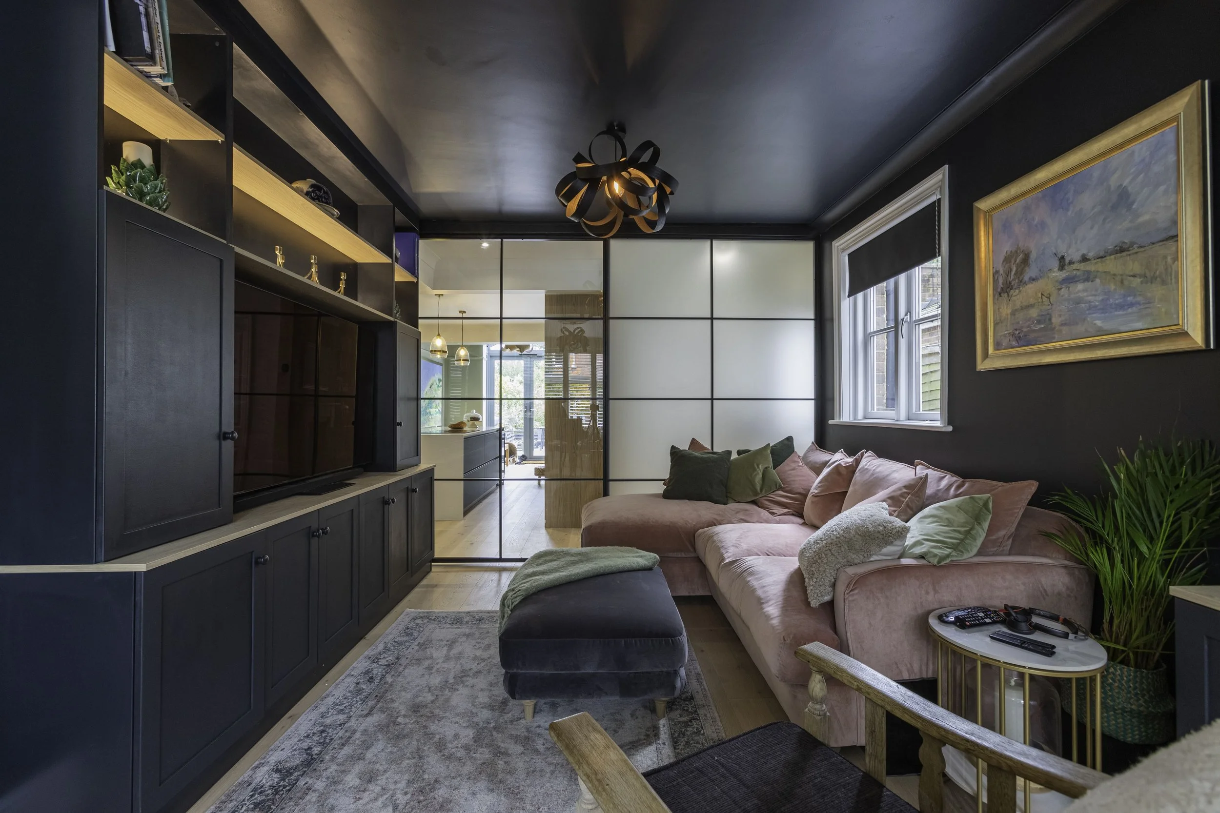 Steel sliding door with fixed screen dividing a kitchen and snug while maintaining open flow