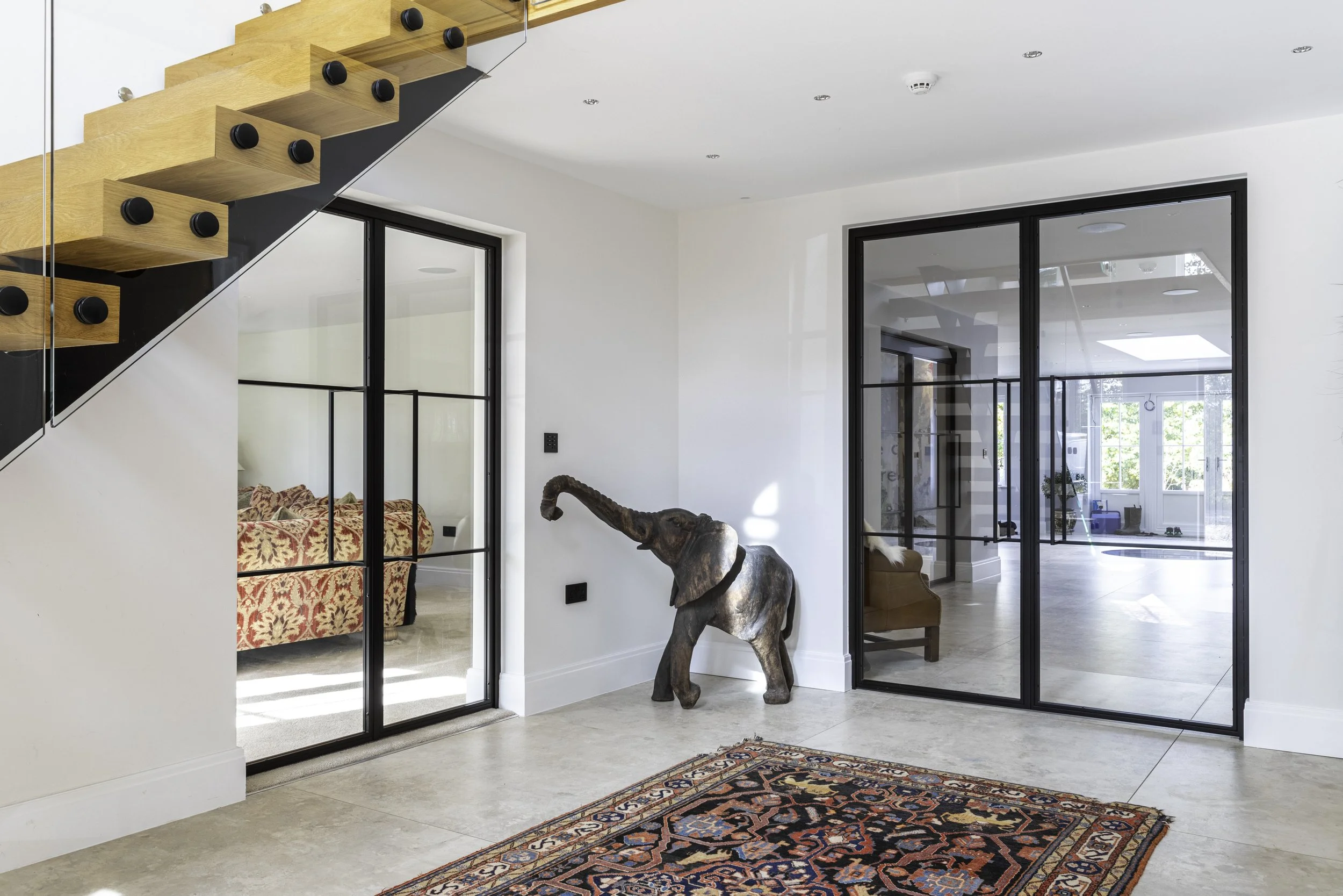 Bespoke double steel internal doors dividing a hallway and living space in a residential property in Little Leighs Essex by Joshua James.
