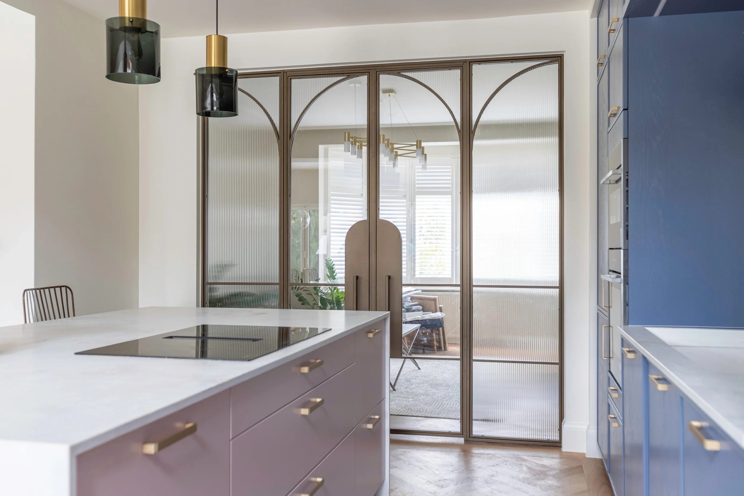 Full-height bronze steel double doors in a modern London townhouse hallway showcasing 2025 design trends