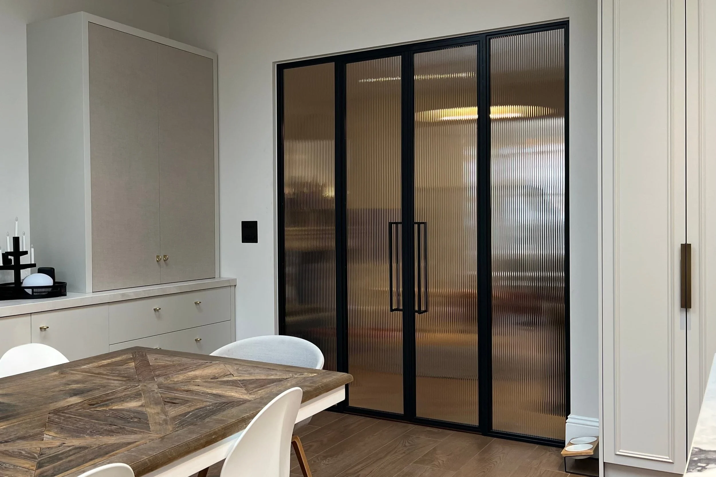Steel framed doors with reeded glass providing privacy between kitchen and living space.