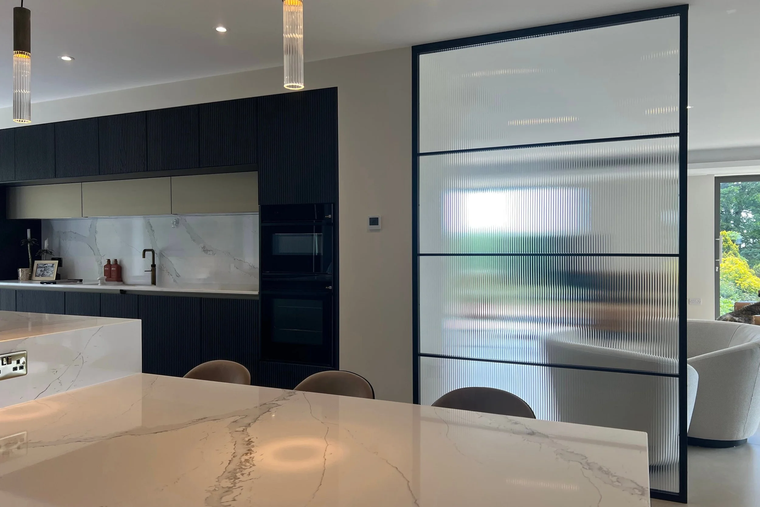 Floor to ceiling bespoke steel internal room divider in a luxury home interior by Joshua James.