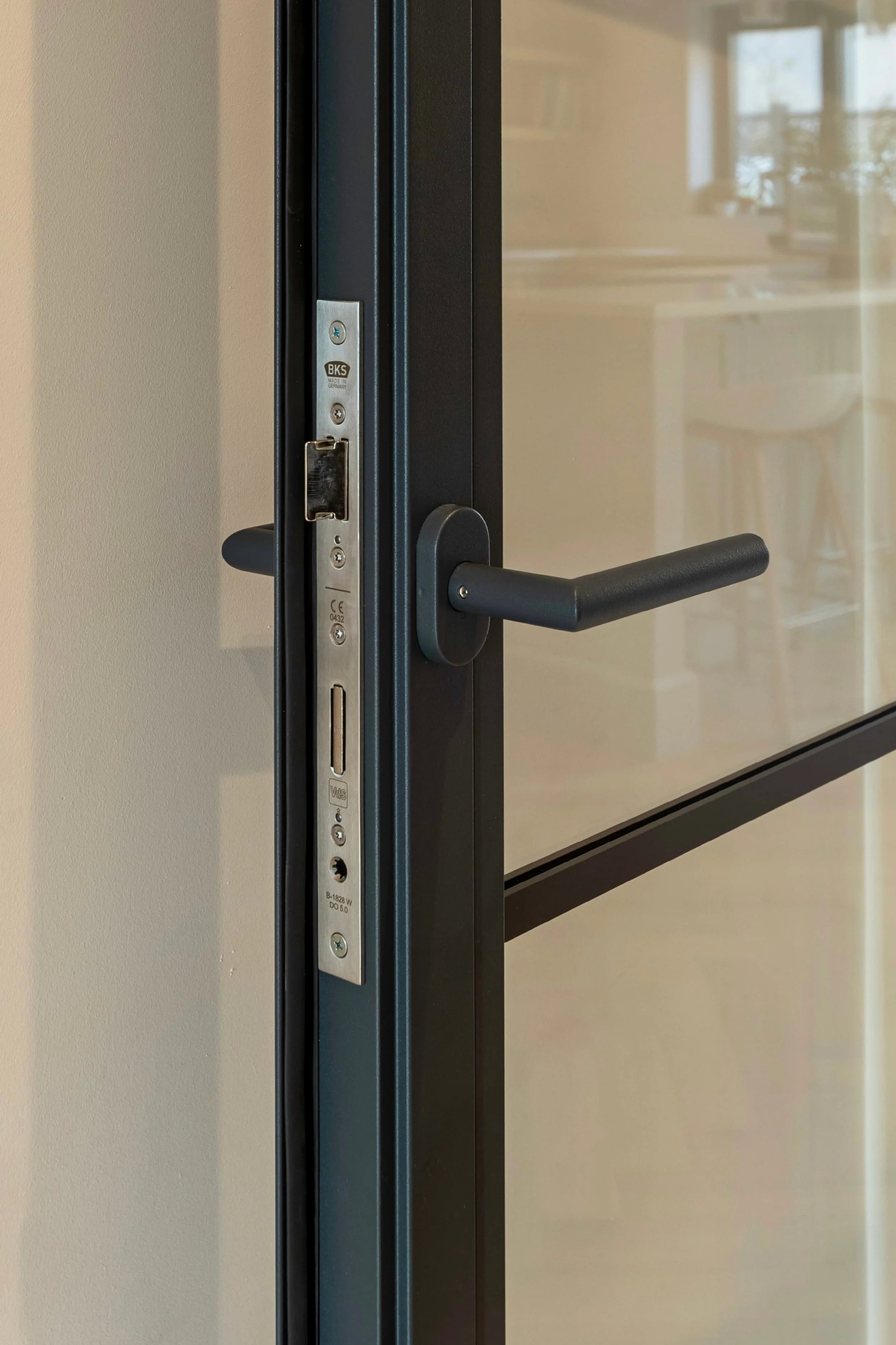Close up of black lever handle on a steel framed fire rated internal door in a Surrey home.