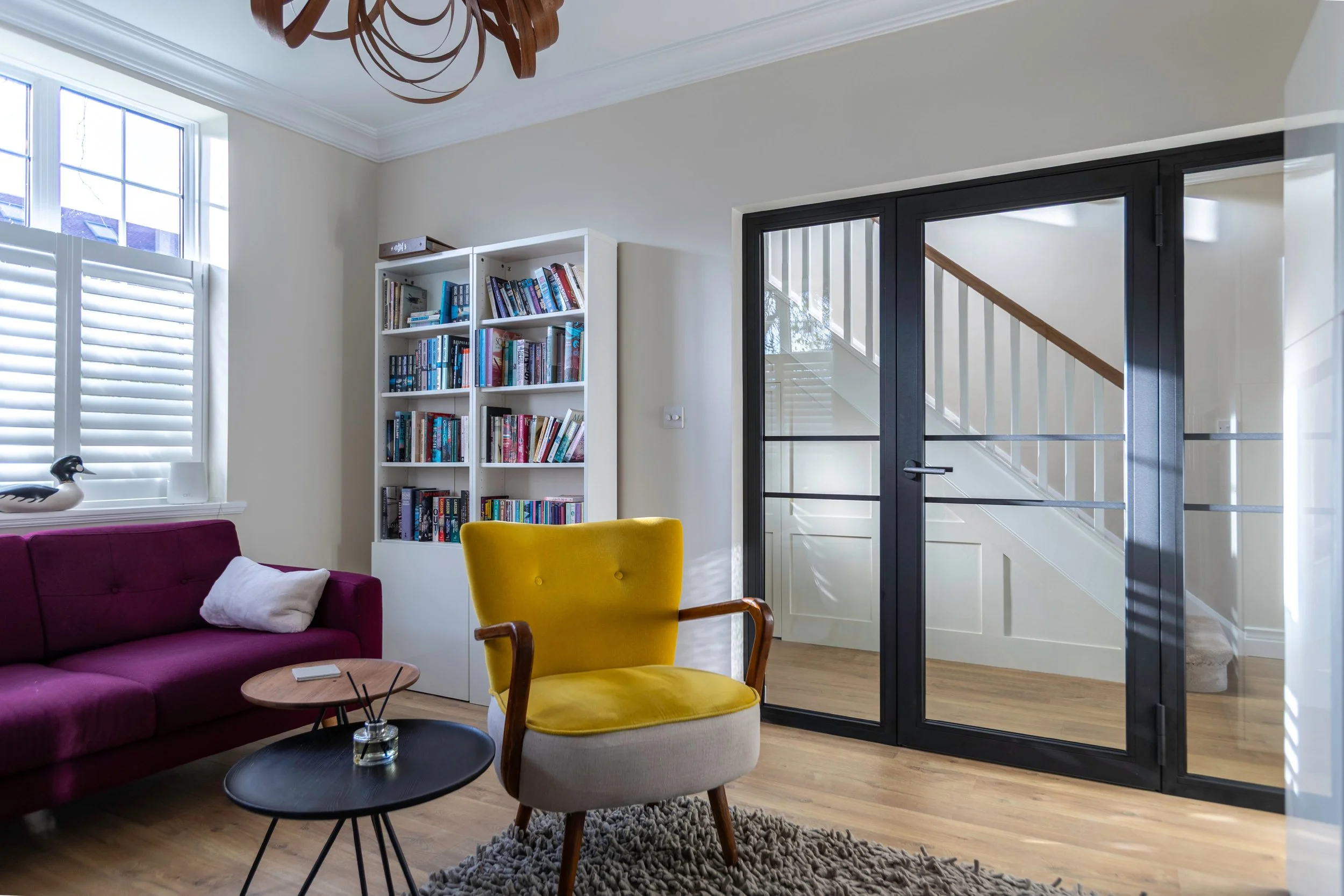 Fire-rated steel single door with glazed side panels forming a protected escape route in a luxury residential property