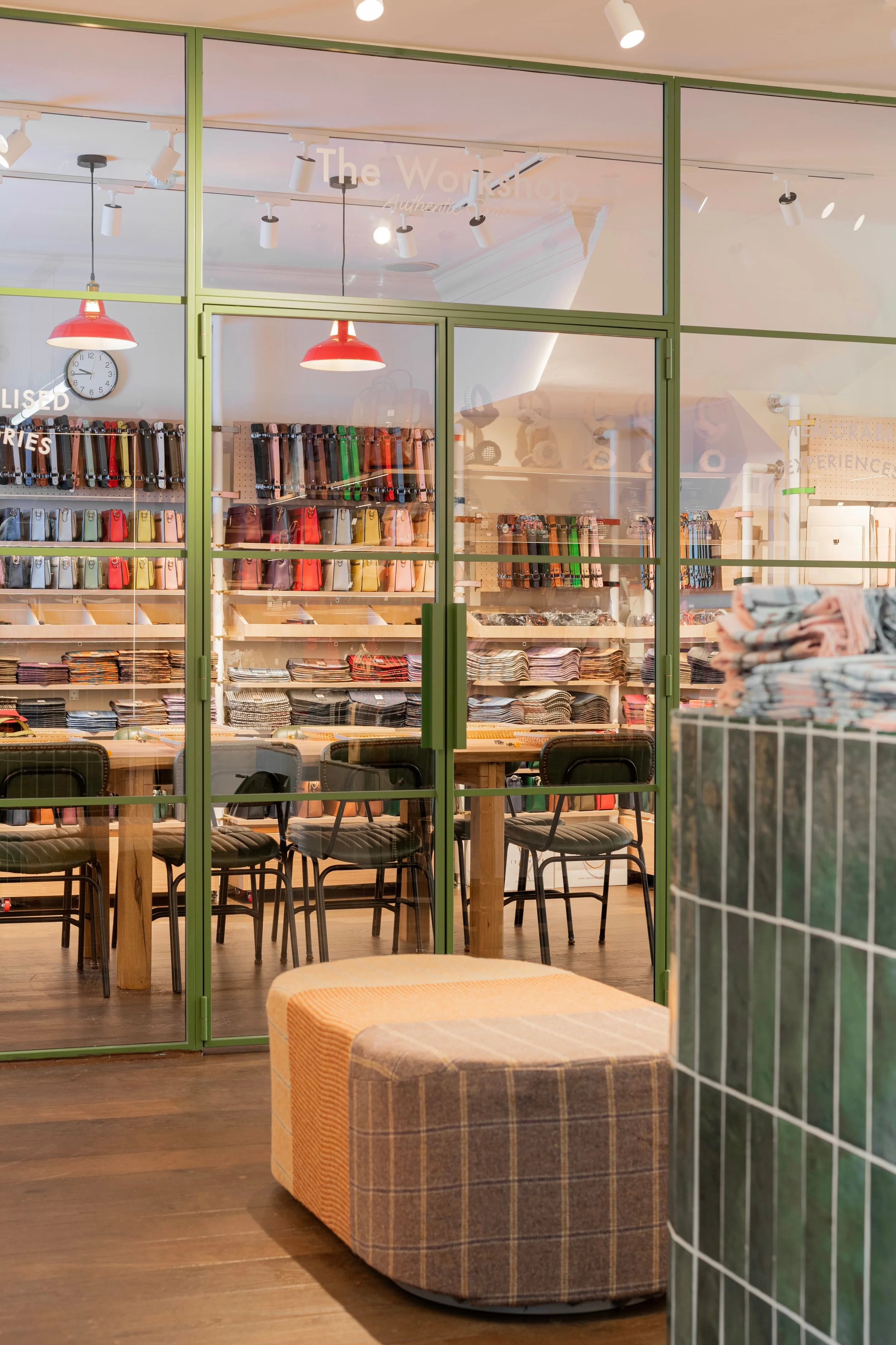 Olive green steel-framed glazing by Joshua James with a view into Islander UK's workshop tables and shelving in Covent Garden.
