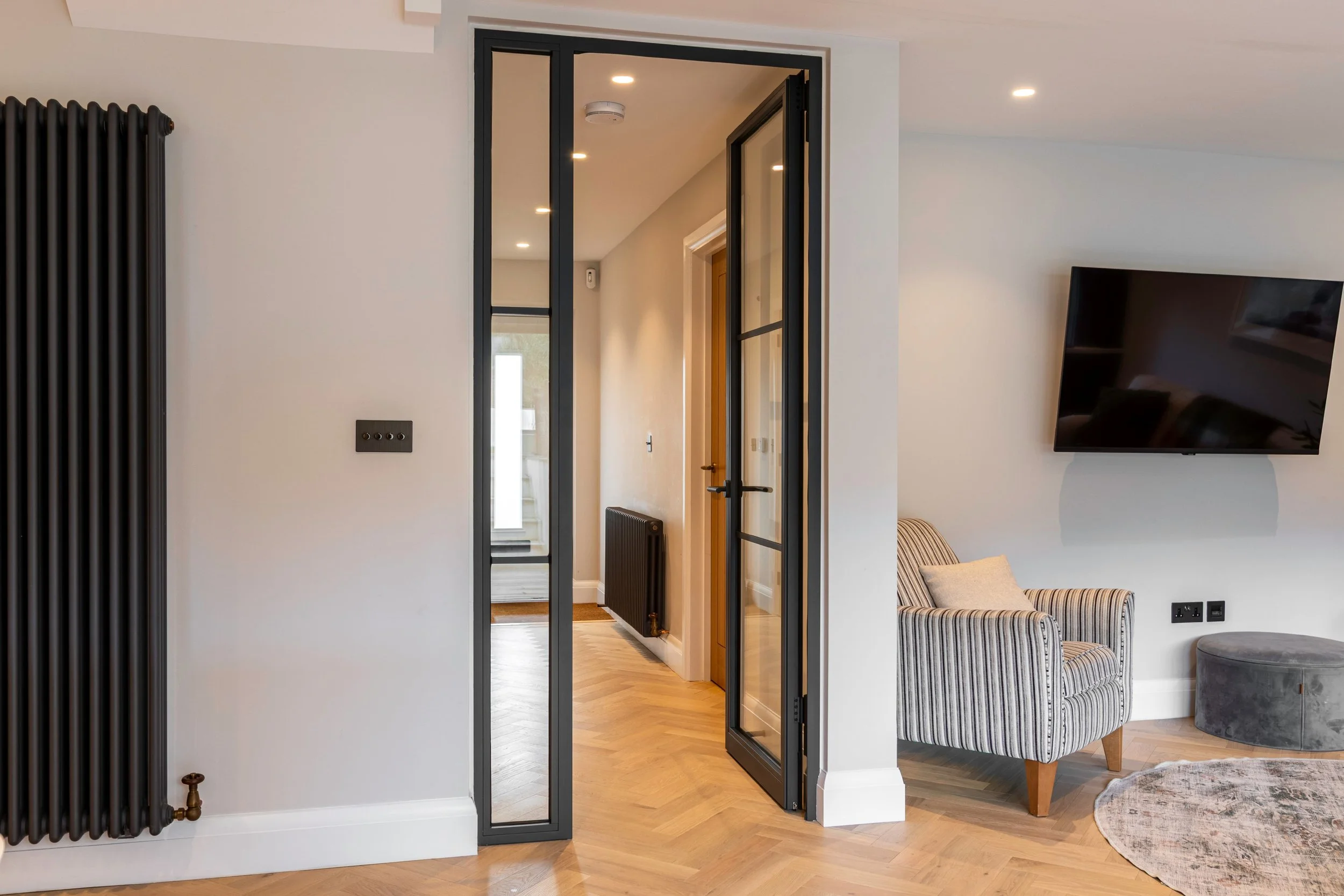 Steel framed fire rated single door with fixed screen shown open in an open plan Surrey home renovation.