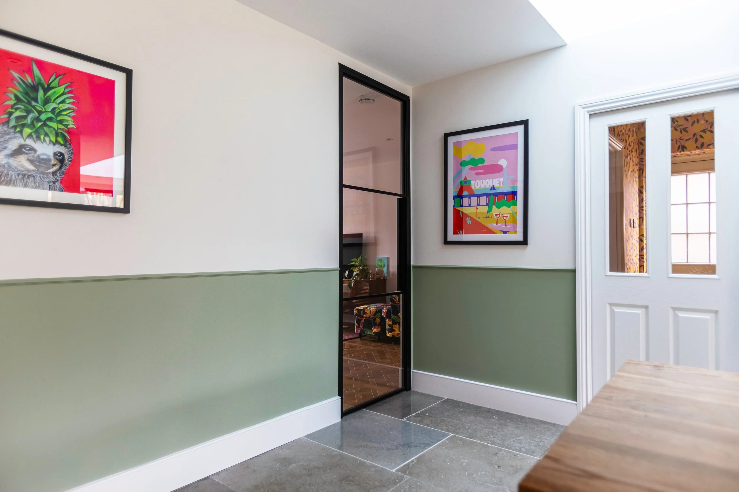 Single internal steel door with two horizontal bars dividing living room and kitchen dining space in Oxted Surrey.