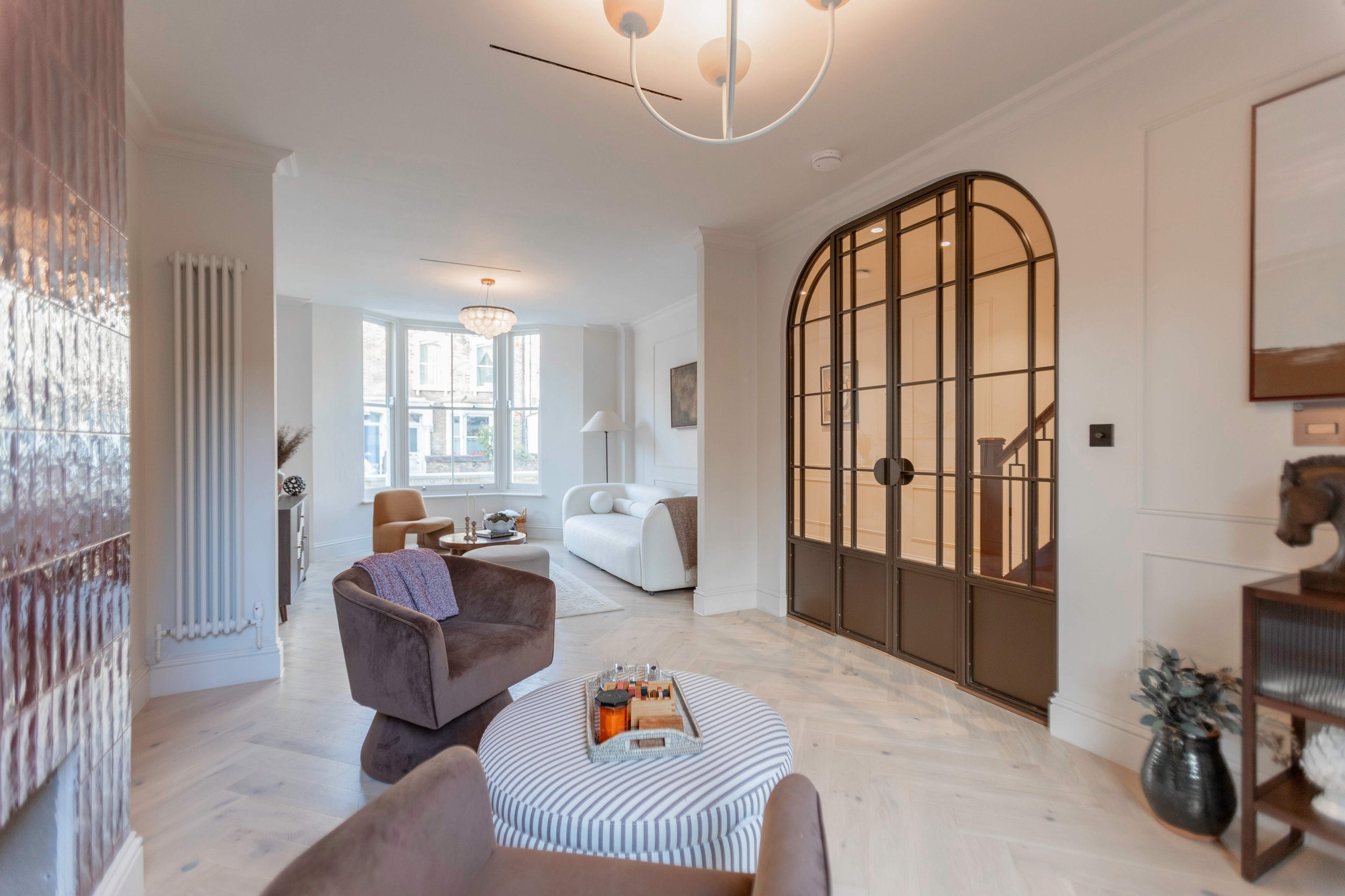 Bespoke bronze steel internal door set with arched fixed screens in a period London property by Joshua James.