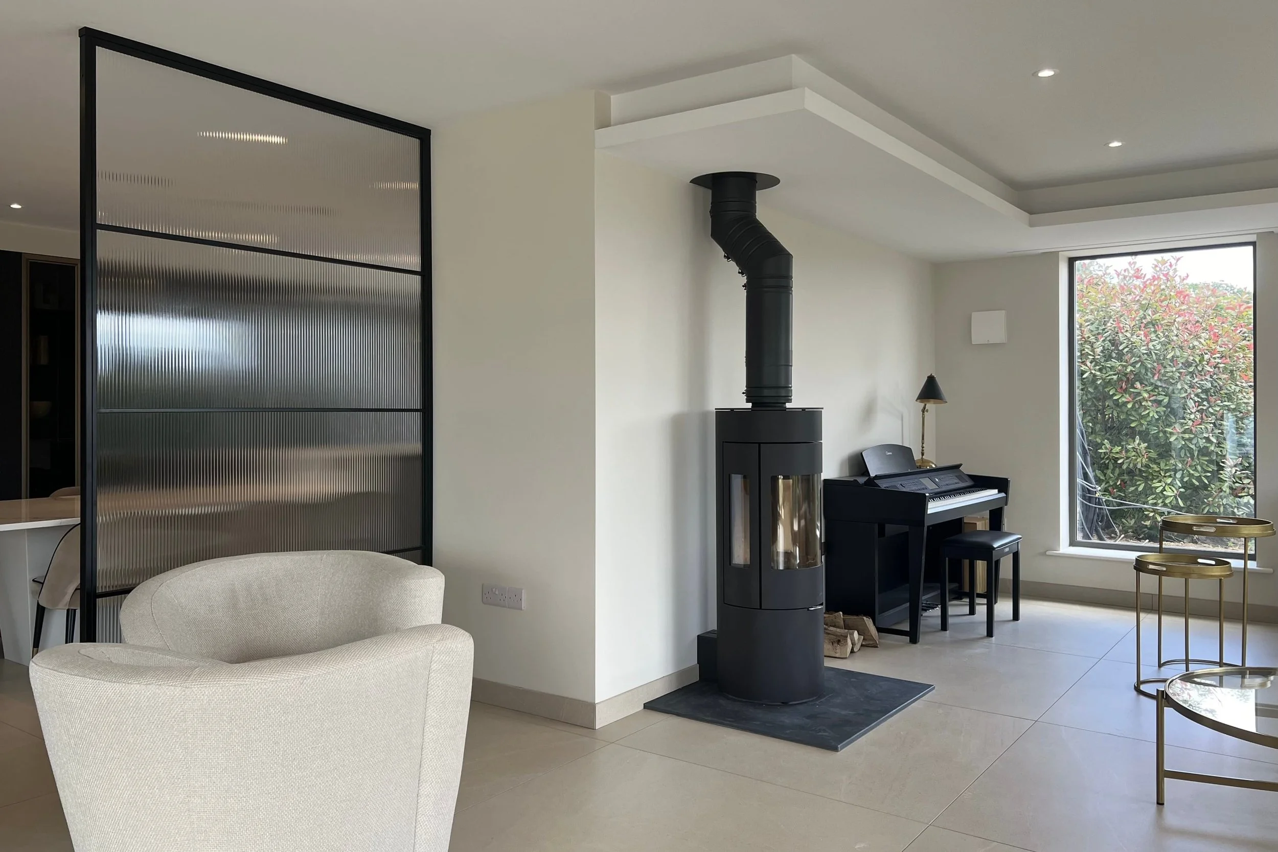 Open ended steel room divider with reeded glass in an open plan kitchen and living space by Joshua James.