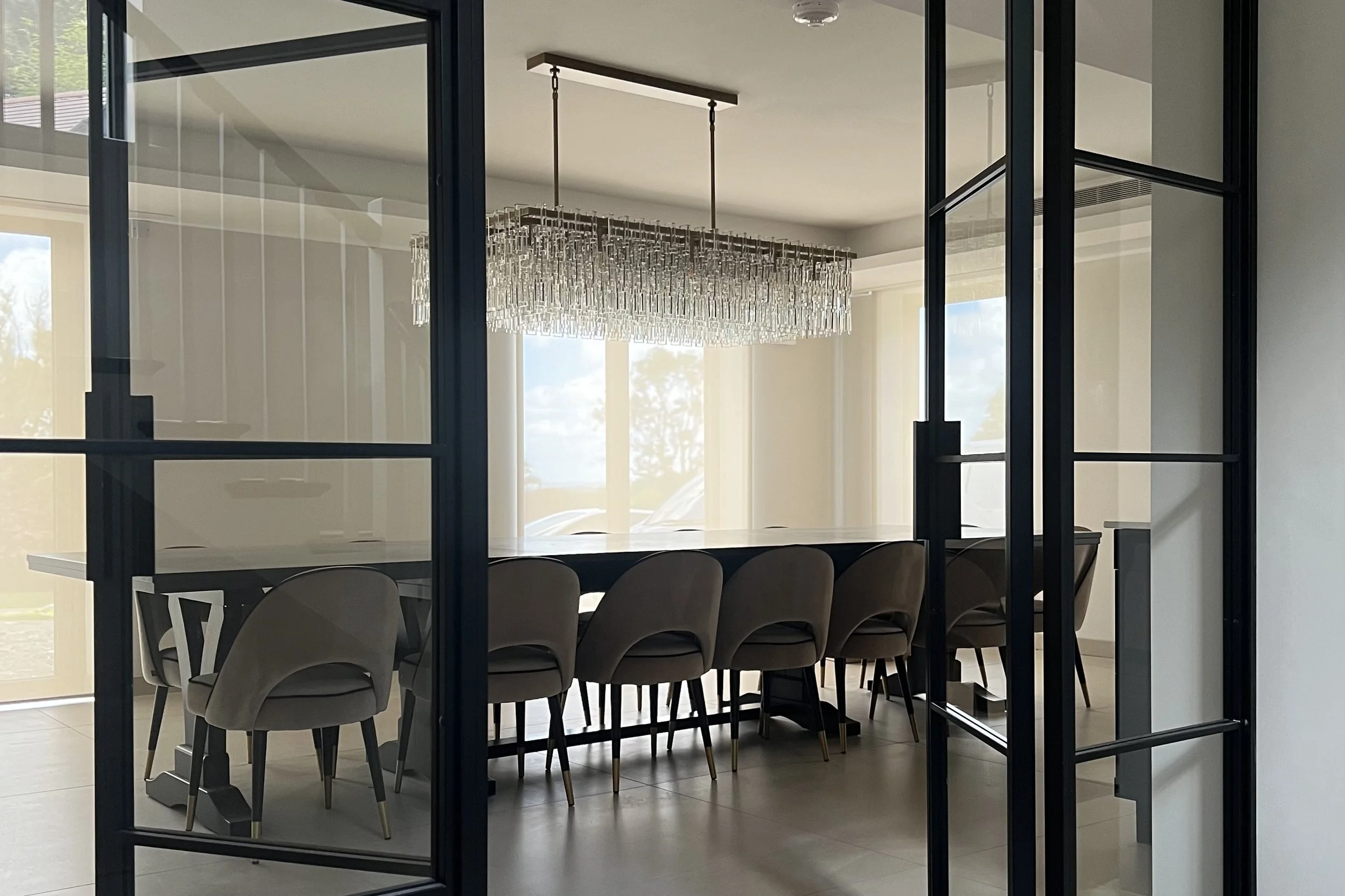 Slim steel frame and glazed panel detail in a broken-plan luxury home interior by Joshua James.