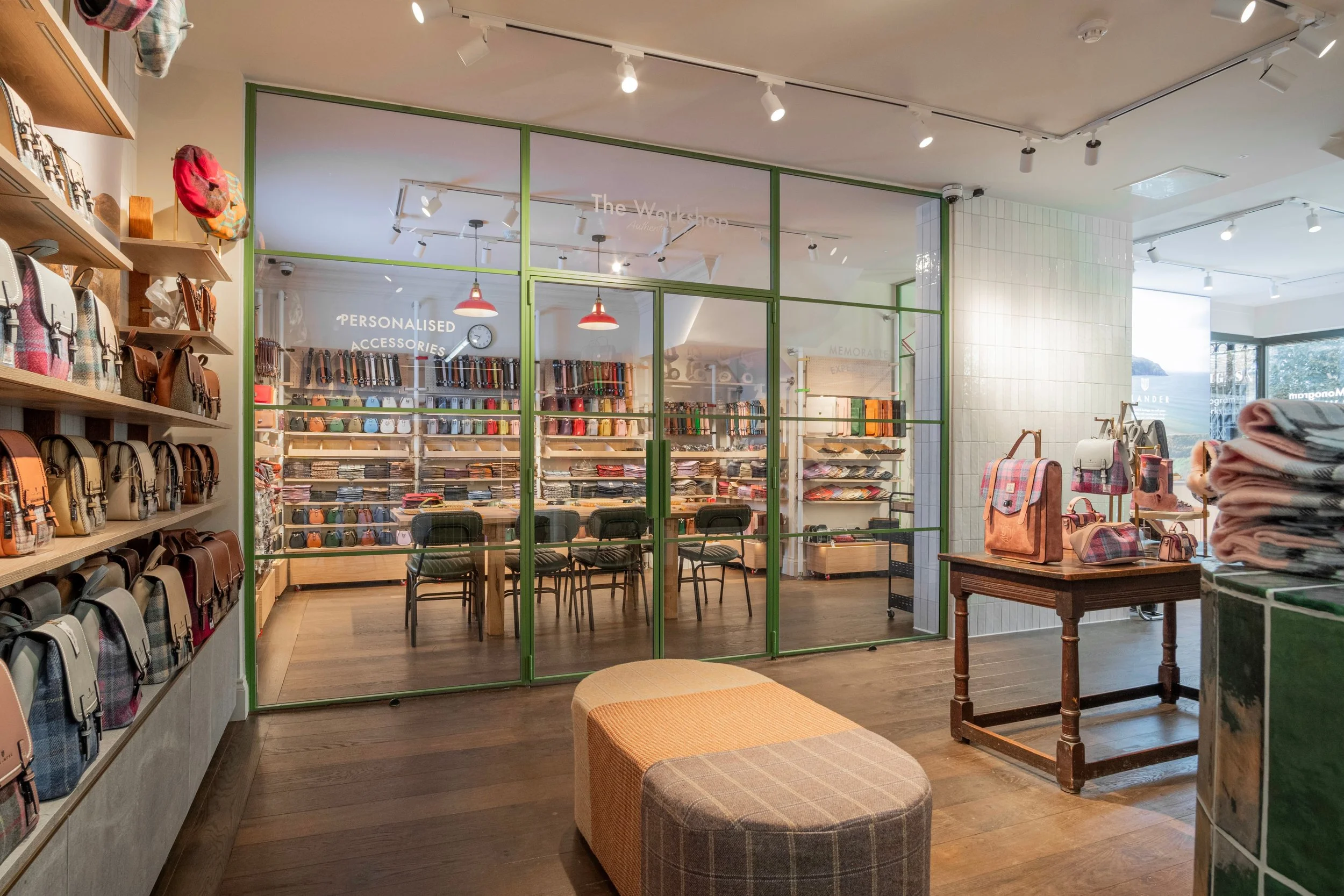 Olive green steel-framed glazing by Joshua James dividing the retail floor from the workshop at Islander UK's Covent Garden store.