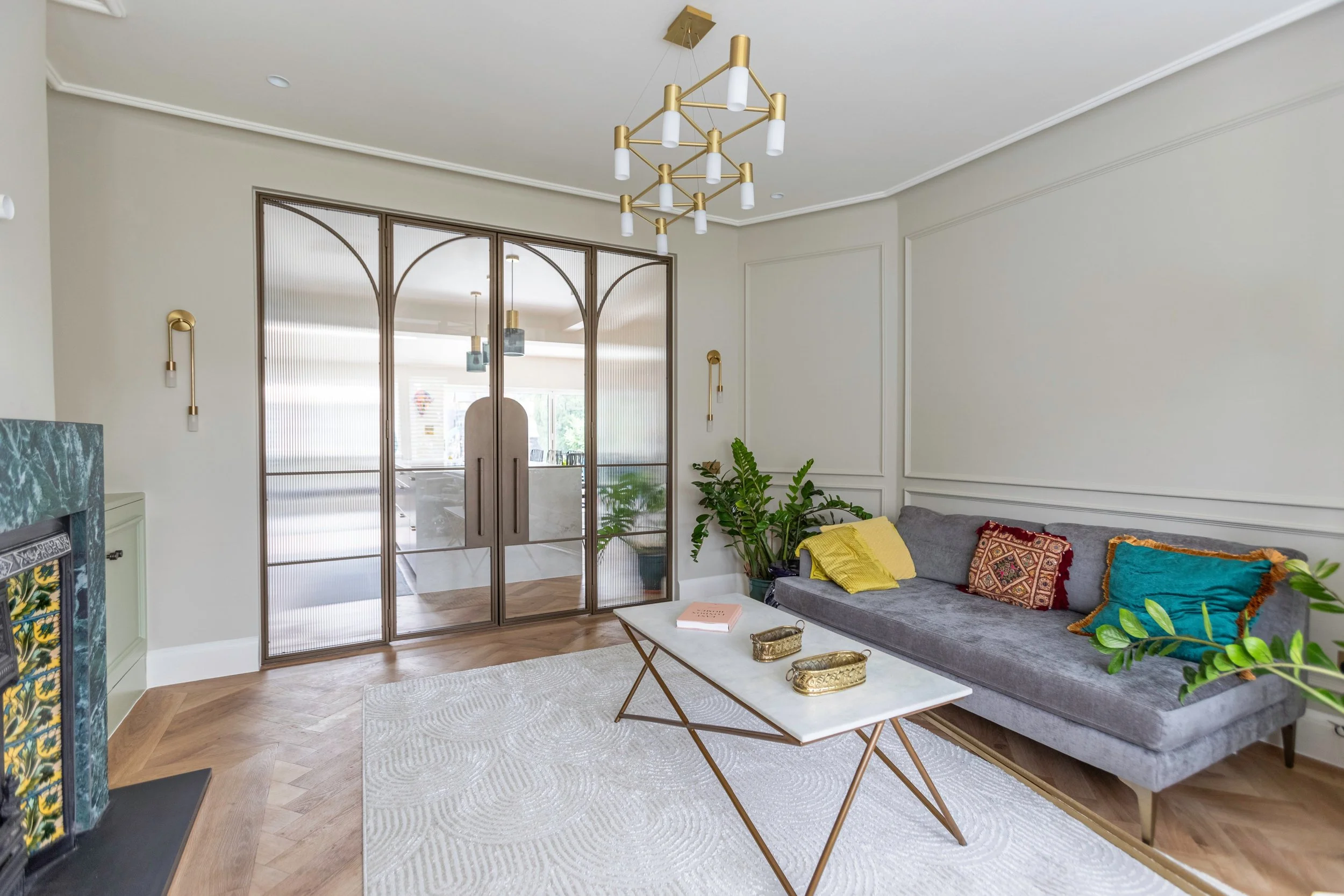 Steel doors allowing light to pass between a kitchen and living room.