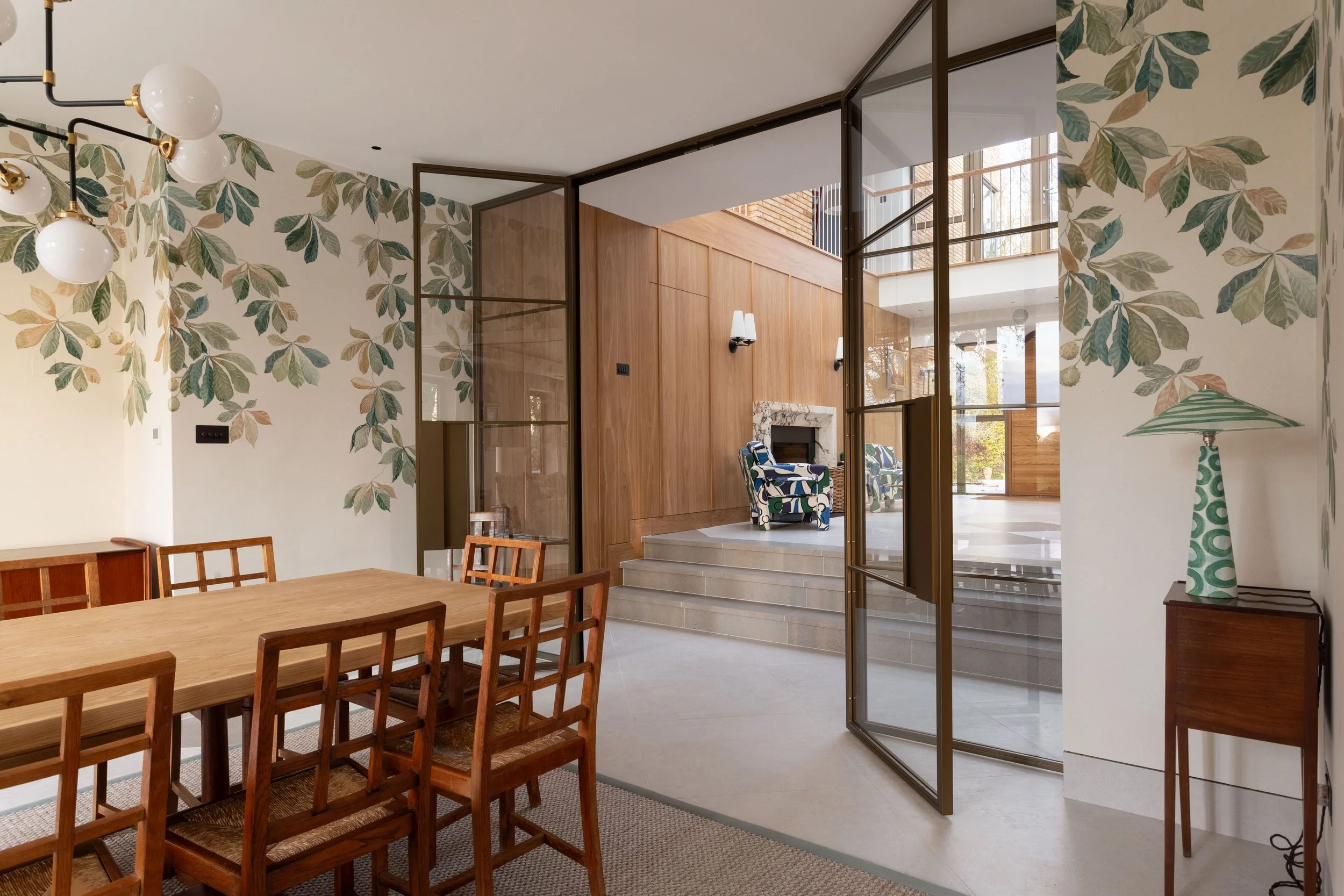 Steel doors creating a statement feature between hallway and reception room in a luxury home.