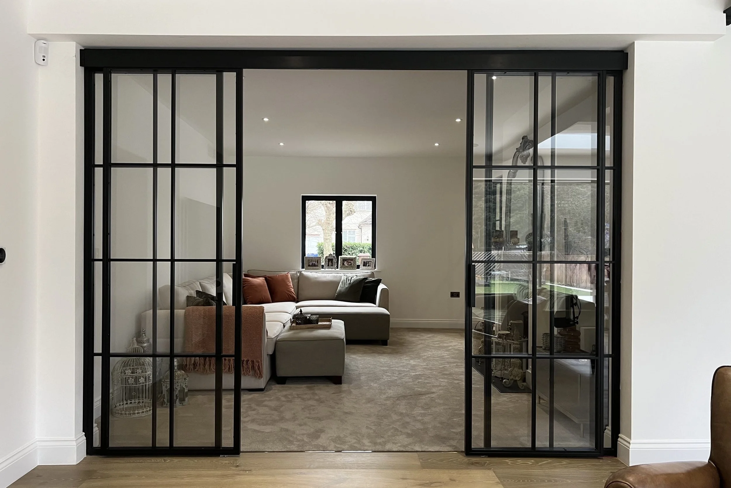 Double steel sliding door with clear glass creating a private home snug near the kitchen/diner