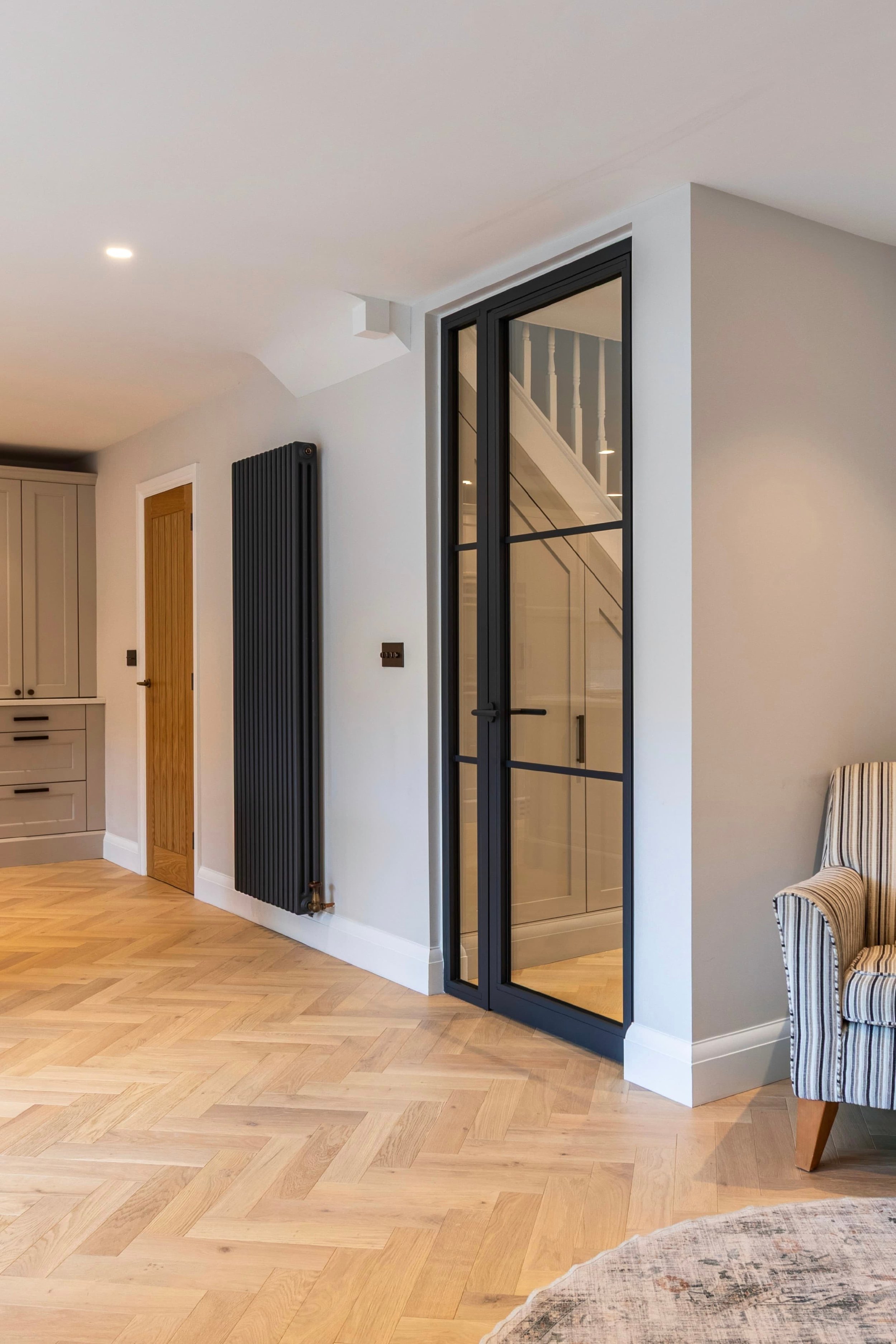 Steel framed fire rated single door with fixed screen in a modern Surrey home interior between hallway and kitchen.