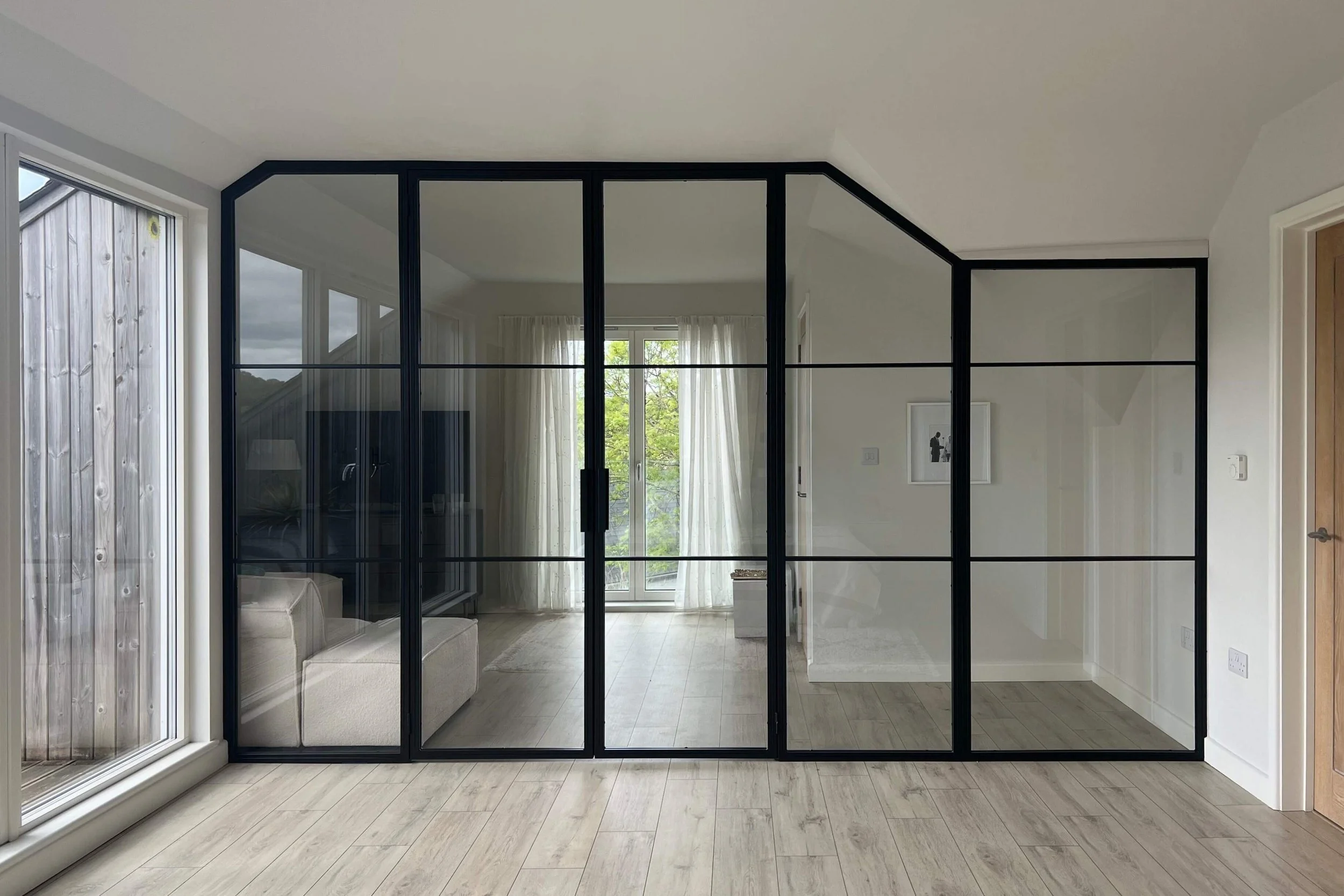 Steel framed partition with specialist glass providing separation within a luxury home