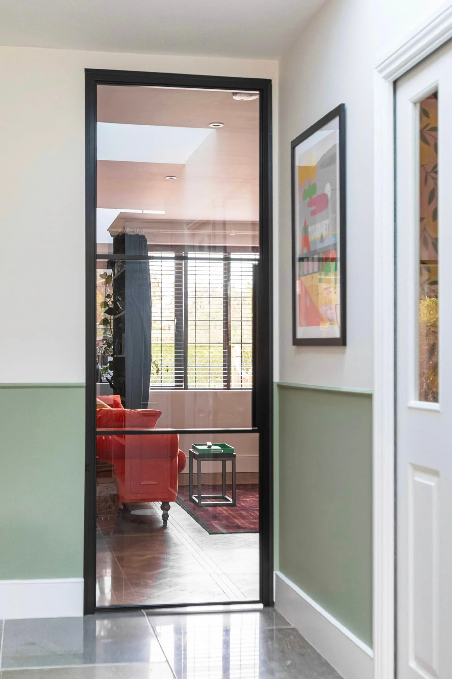 Single internal steel door with two horizontal bars viewed from hallway into living room in Oxted Surrey.