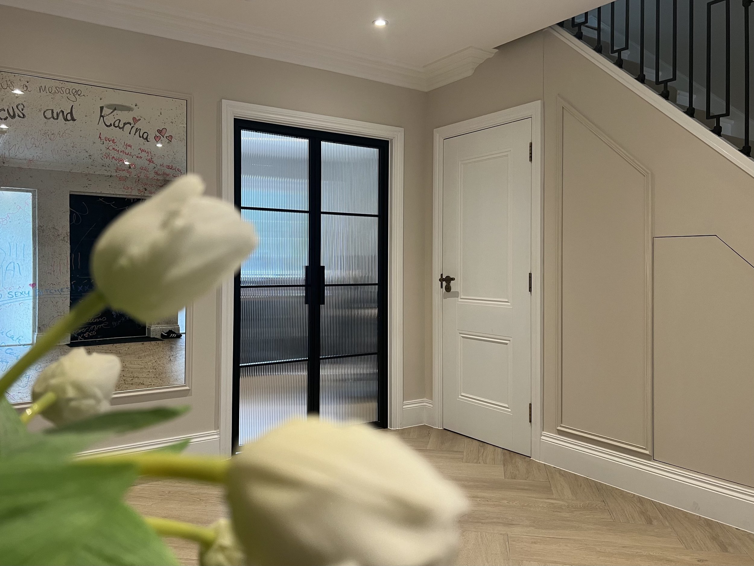 Black steel door with reeded glass for privacy in a luxury home office.