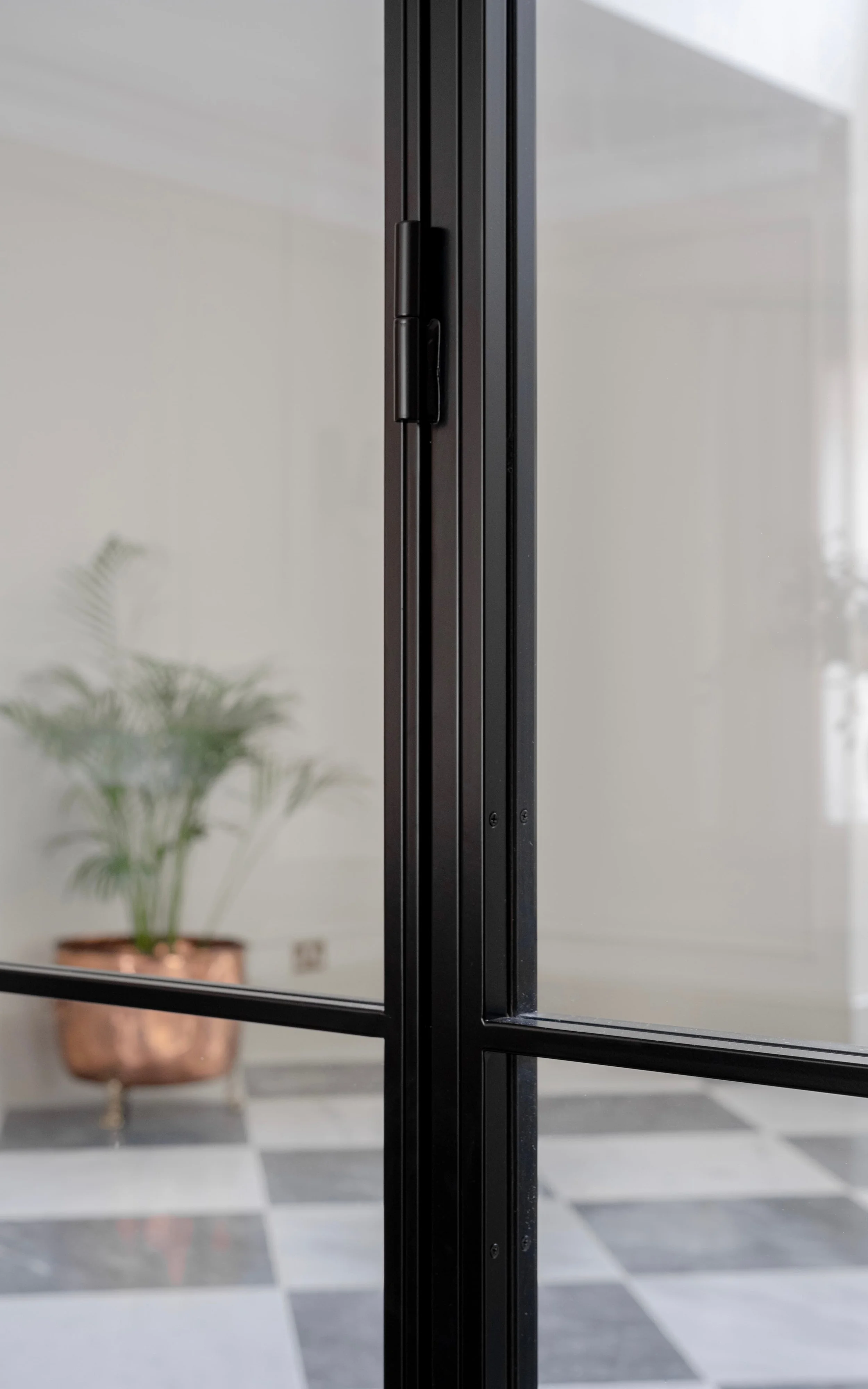 Close-up of the InoCross20FR steel-framed fire-rated double doors, showcasing the slim steel profiles, discreet hinge and horizontal glazing bars.